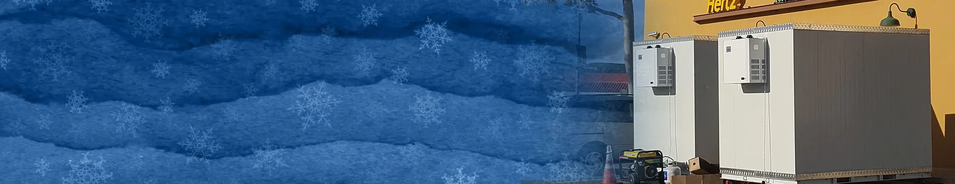 Two large white cooling units outdoors beside a yellow building with a Hertz logo.