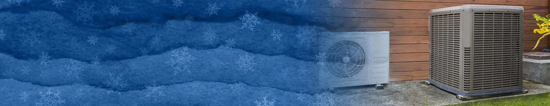 Two outdoor heat pump units installed on concrete pads next to a wooden wall.