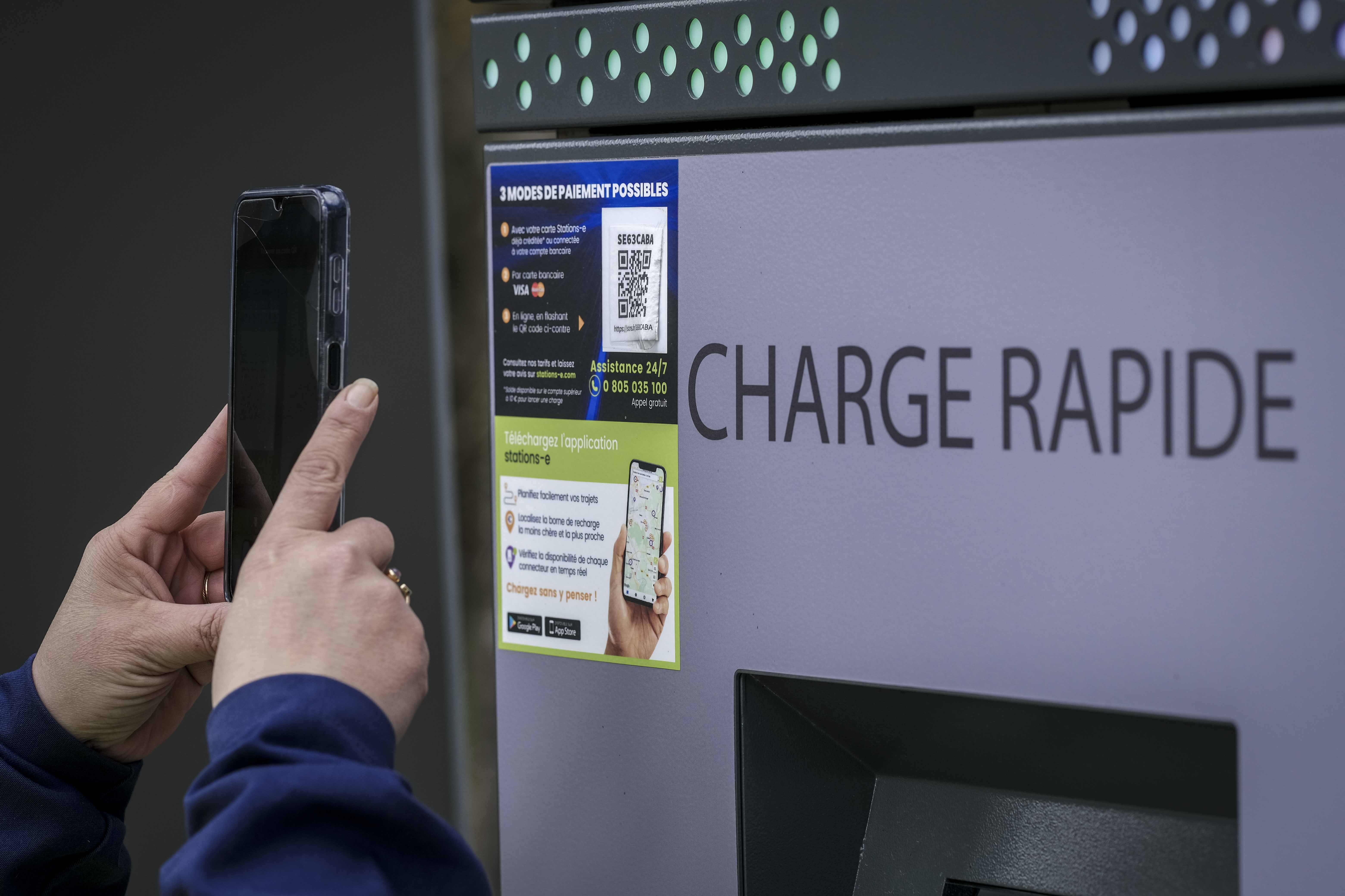 Hand scanning QR code for Circet Energy high-power electric vehicle rapid charging station instructions