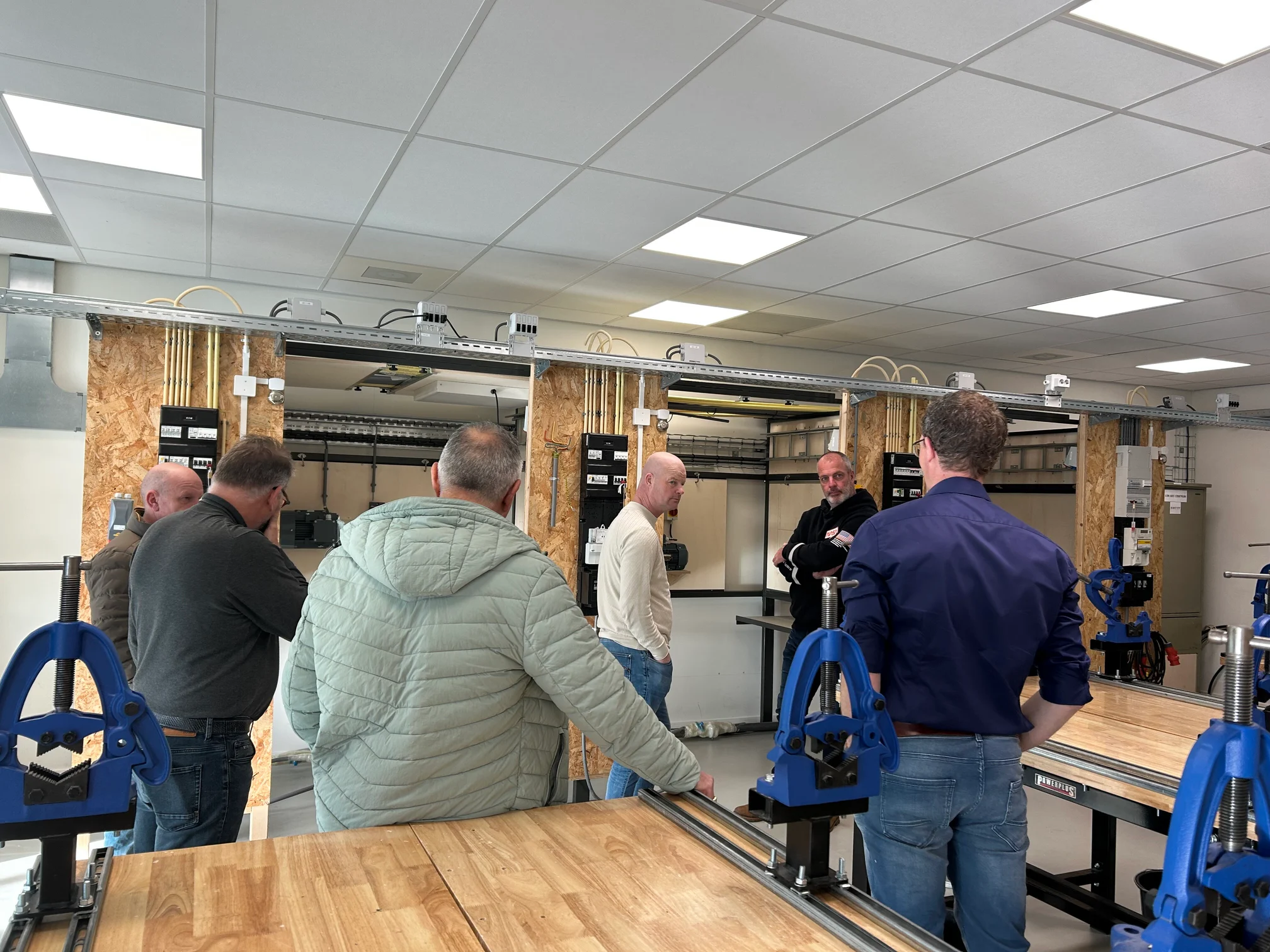 Group observing smart meter installation in medium-voltage substation equipment room