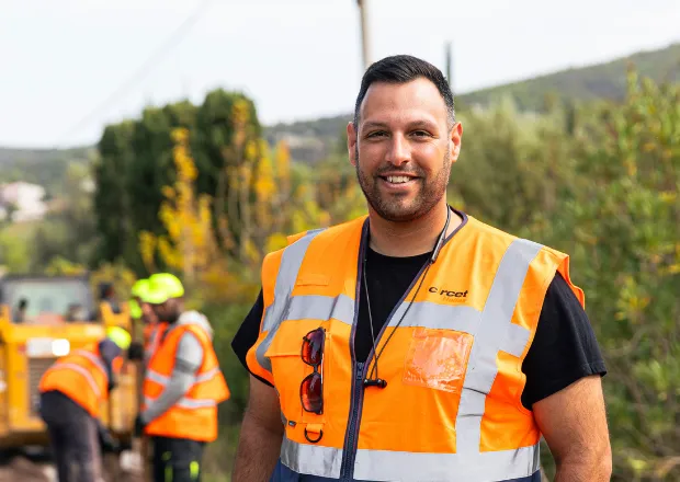 Worker wearing high-visibility safety vest inspecting energy infrastructure site.