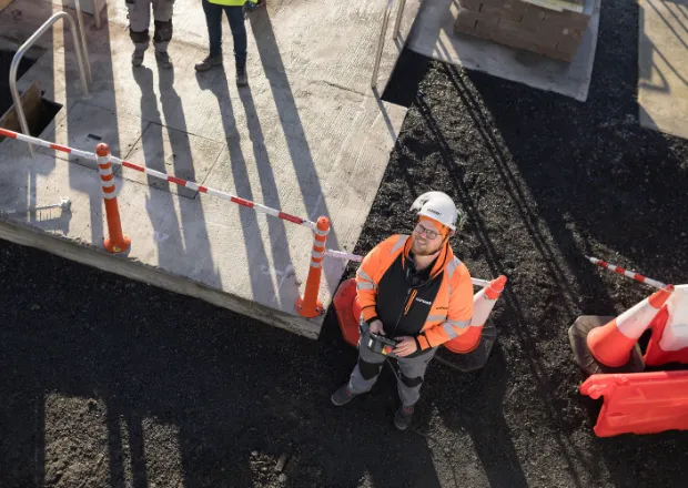 Worker wearing safety gear inspecting high-voltage civil engineering infrastructure site