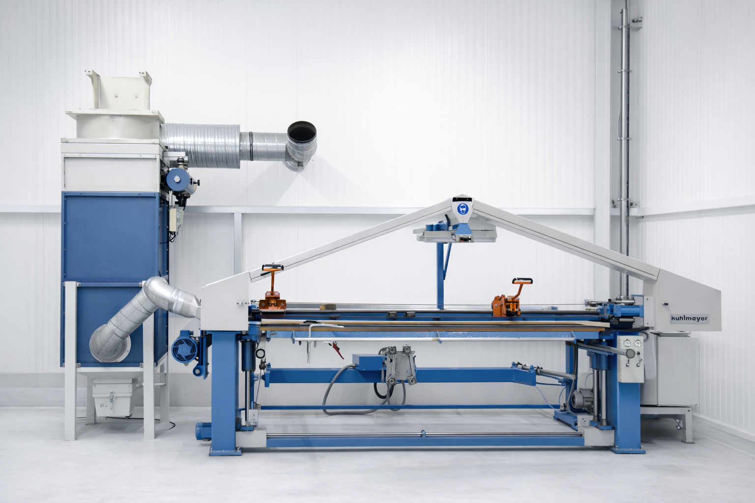 Industrial blue and white Kuhlmayer machine in a clean white factory room with ventilation ducts.
