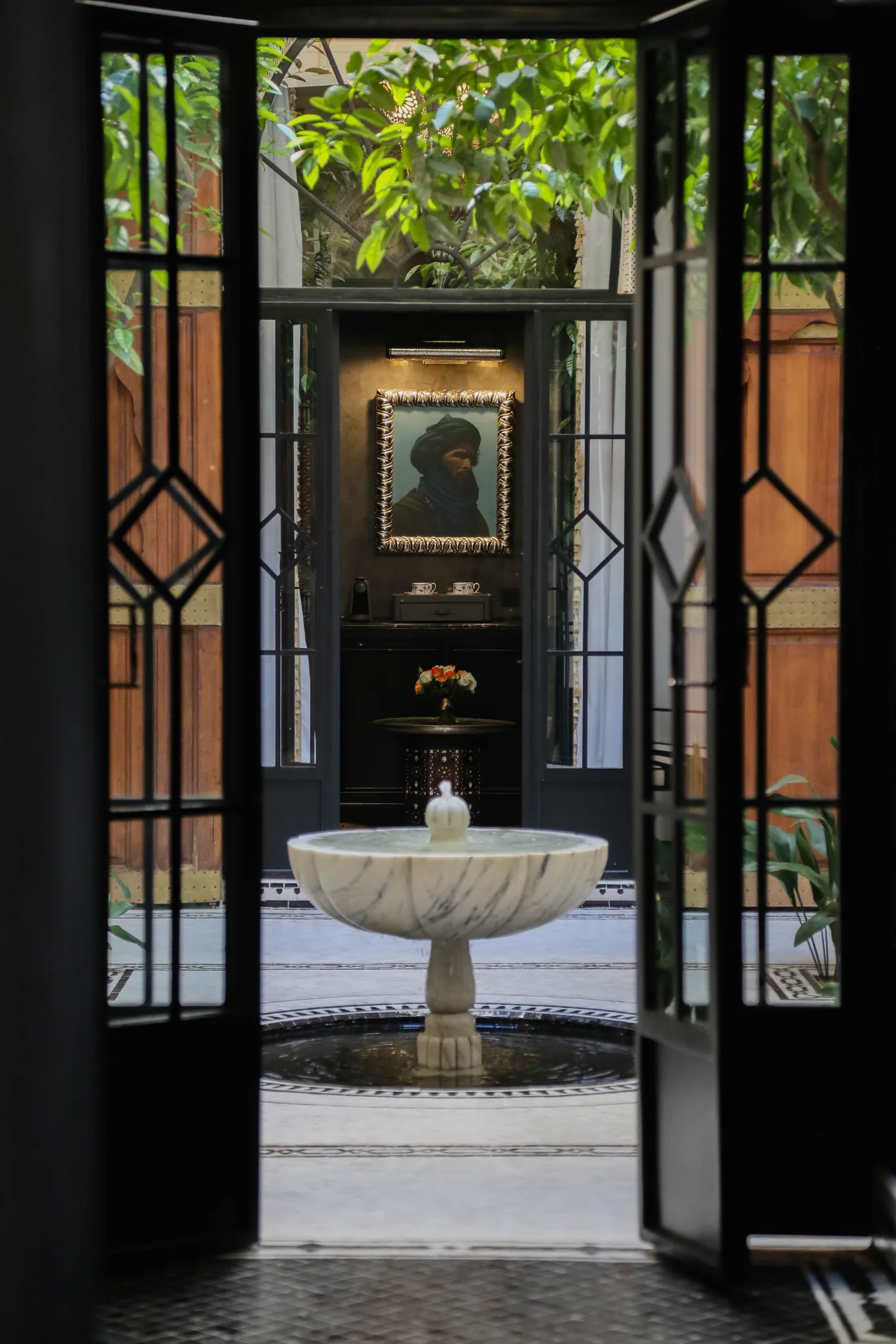 Fountain seen through a carved doorway at Riad Dar Saeed