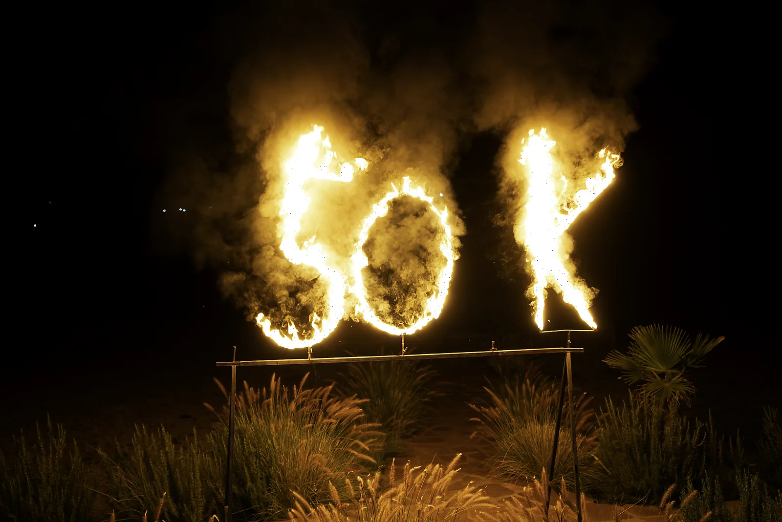 A flaming 50 installation lighting up the night at a milestone birthday celebration in the Marrakech desert