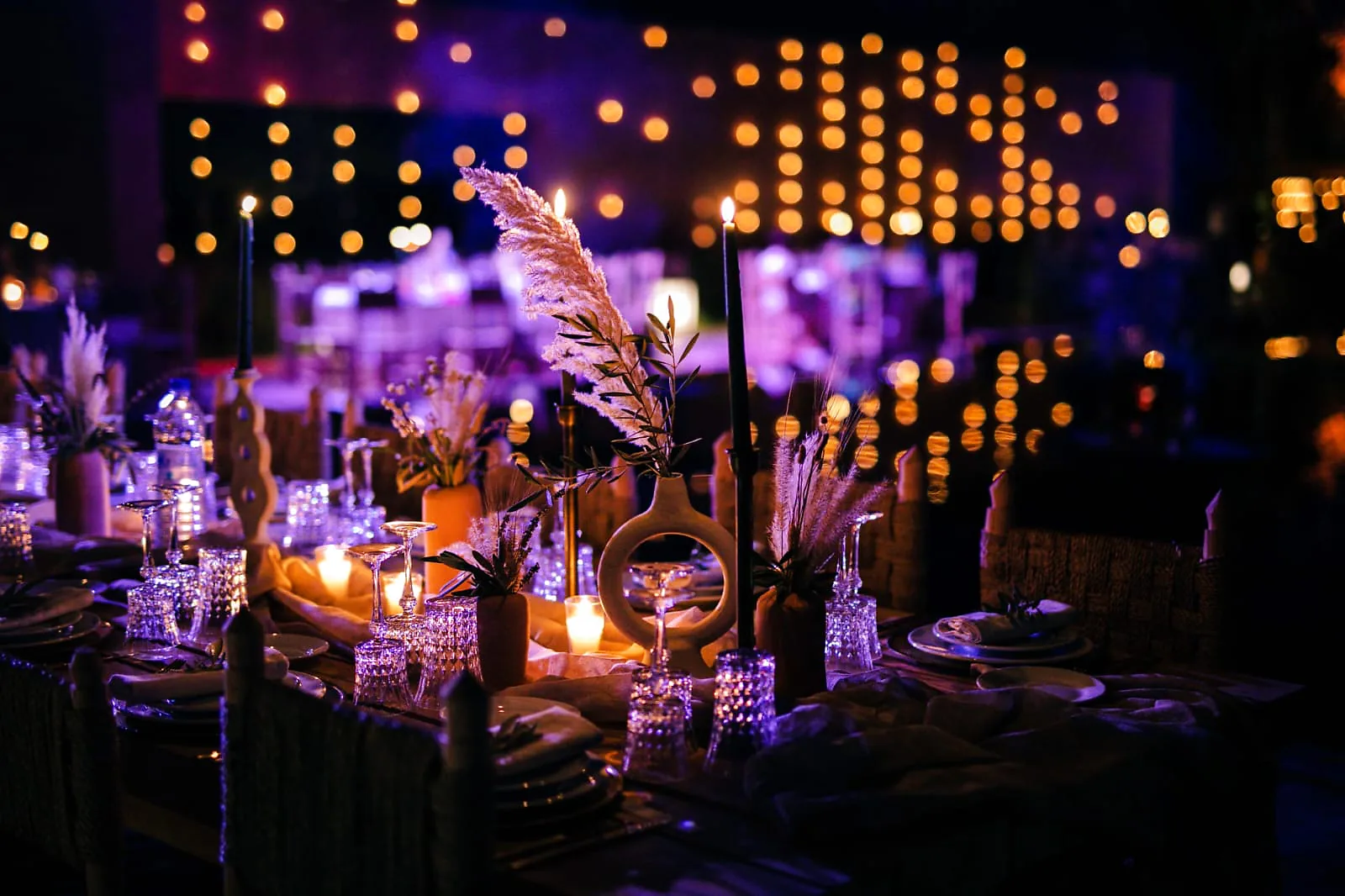 Table de mariage dressée aux chandelles dans une villa privée à Marrakech, de nuit