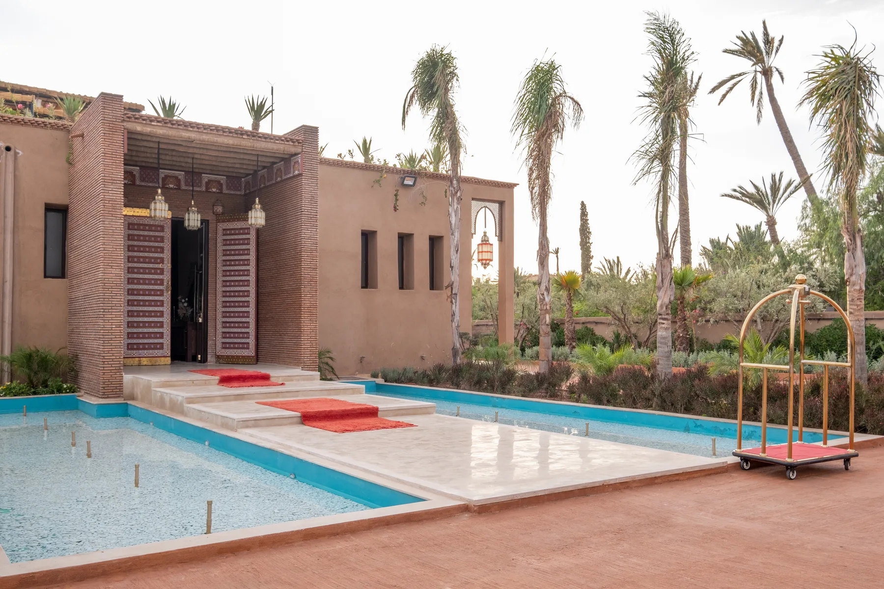 Villa Moira, celebration villa in the Palmeraie, Marrakech, arrival with red carpet along the pool. The Marrakech Curator.