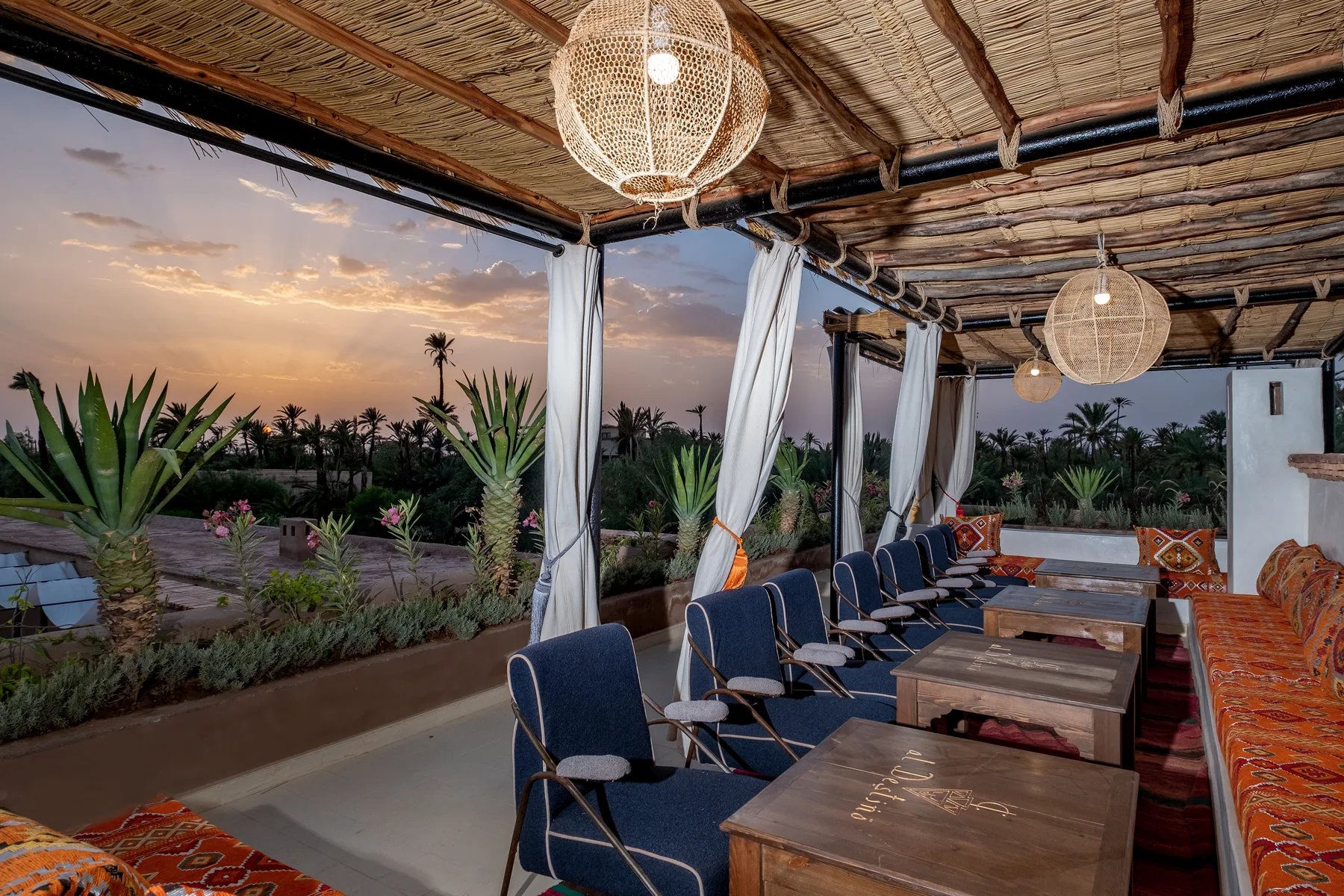 Villa Moira, celebration villa in the Palmeraie, Marrakech, rooftop lounge at sunset. The Marrakech Curator.