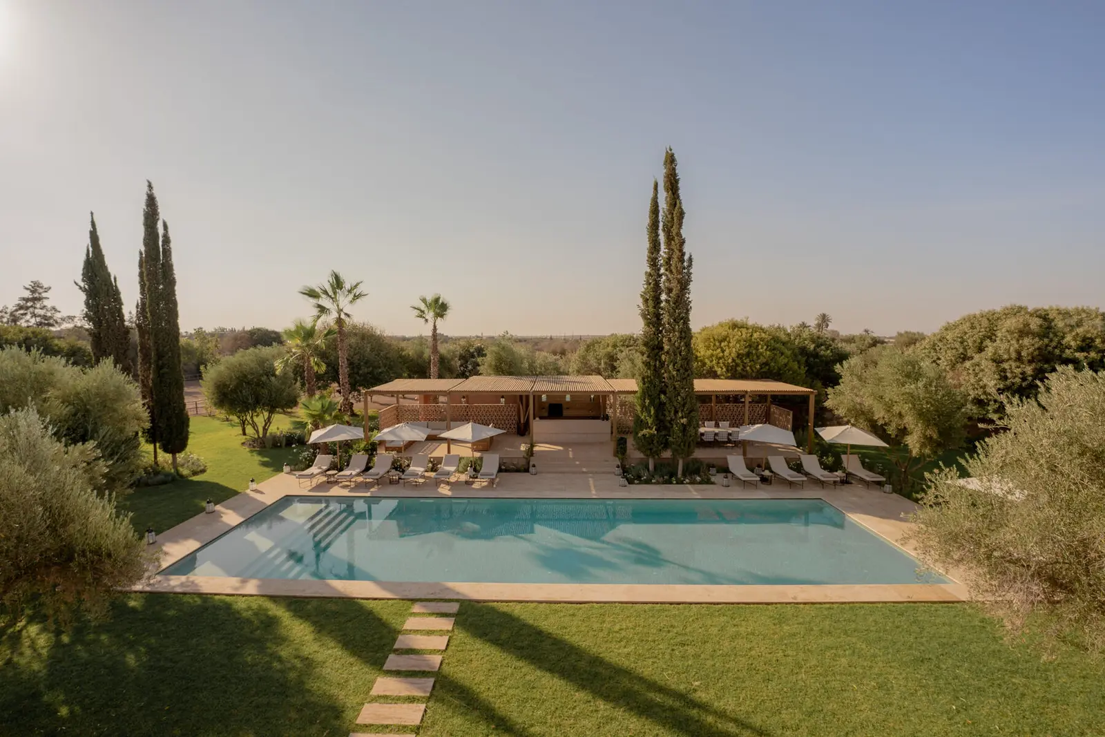 Villa Pegasos, private estate near Marrakech, 20-metre pool under blue sky. The Marrakech Curator.