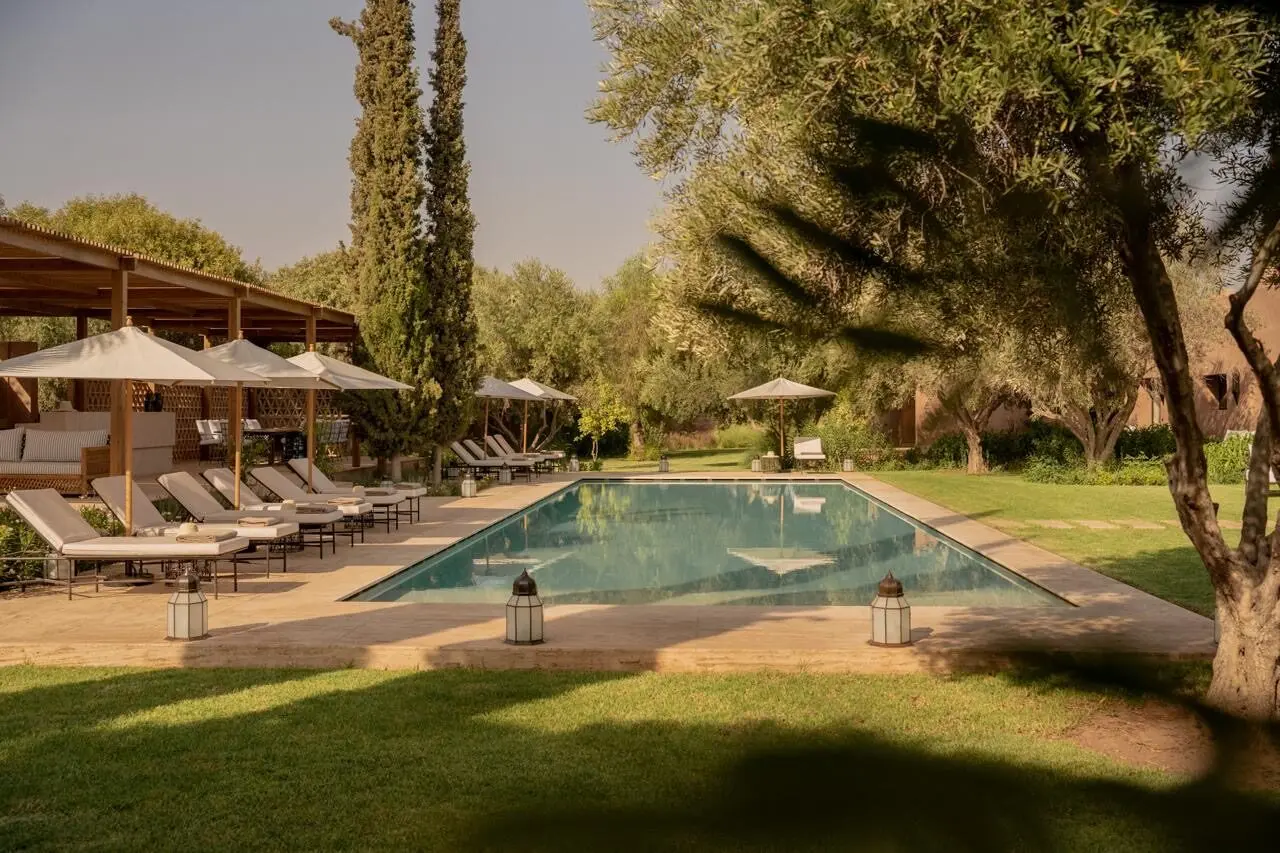 Villa Pegasos, private estate near Marrakech, pool loungers at sunset. The Marrakech Curator.