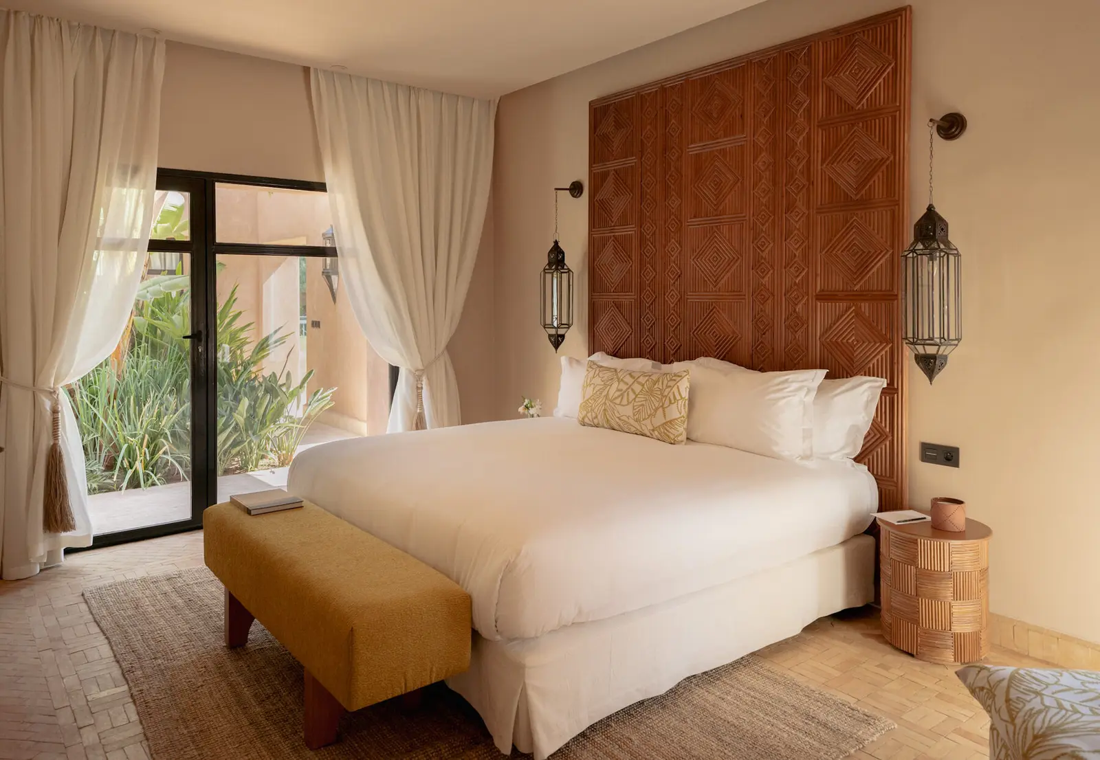 Villa Pegasos, private estate near Marrakech, master bedroom with carved headboard. The Marrakech Curator.