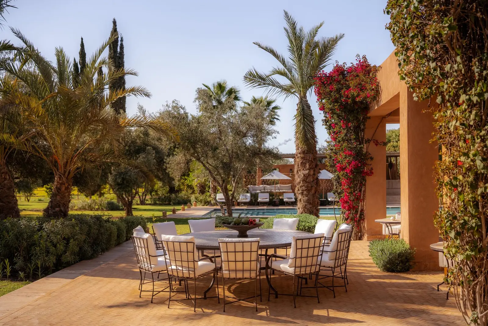 Villa Pegasos, private estate near Marrakech, terrace dining under bougainvillea. The Marrakech Curator.