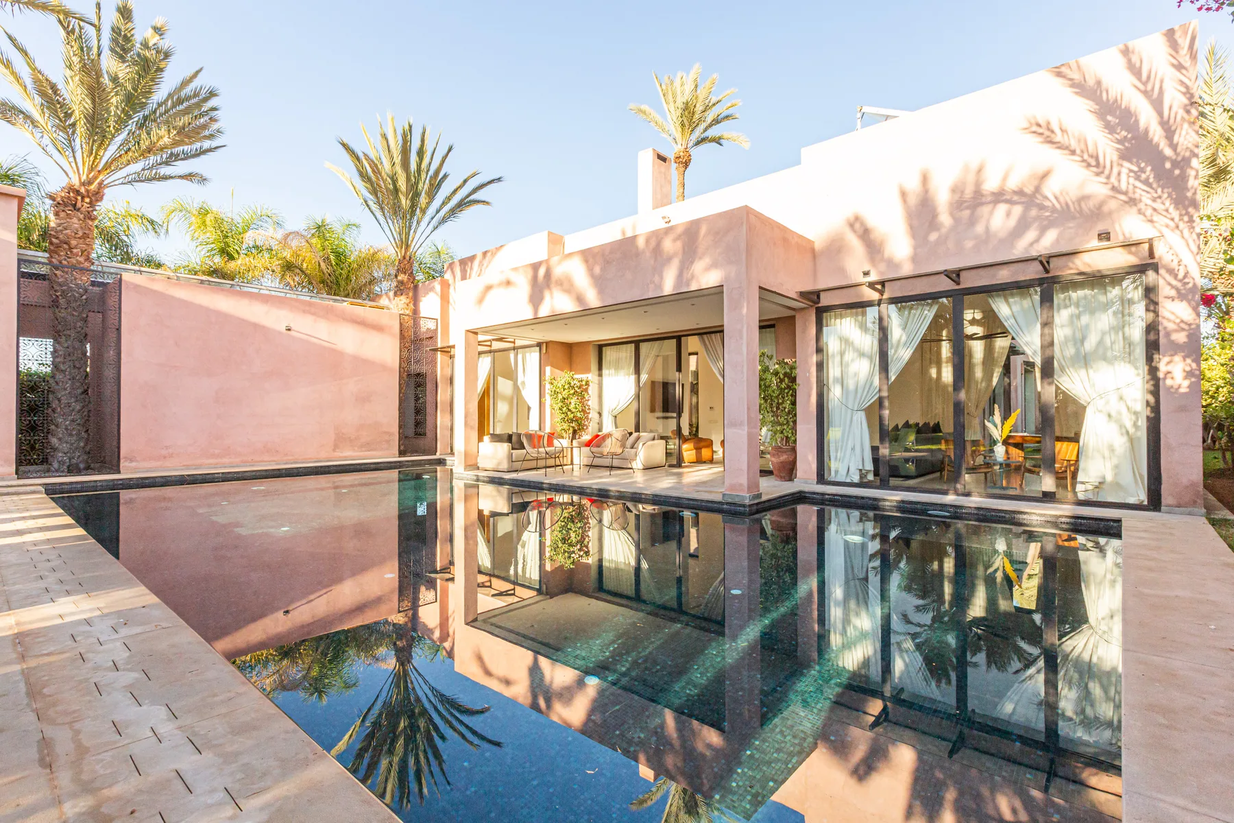 Villa Zephyra, 5 bedroom villa for rent in Marrakech, modern facade reflected in the private pool. The Marrakech Curator.