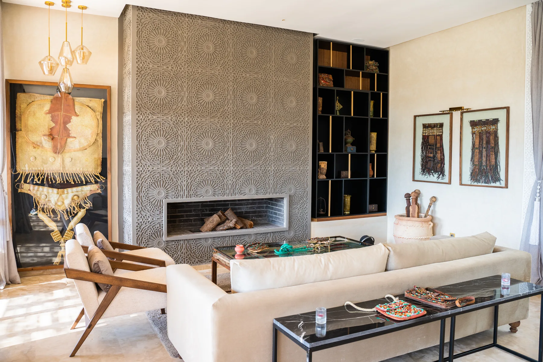 Villa Kallista, 12 bedroom wedding and event villa in Marrakech, salon with carved fireplace wall. The Marrakech Curator.