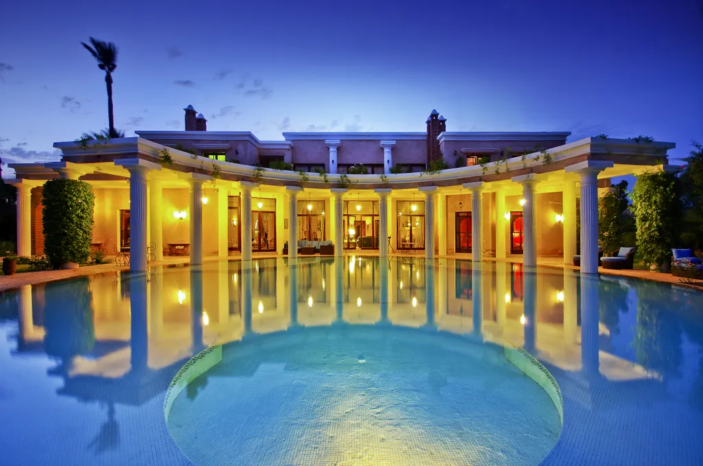 Villa Aegea, private villa rental in the Palmeraie, Marrakech: the pool and colonnade lit up at night