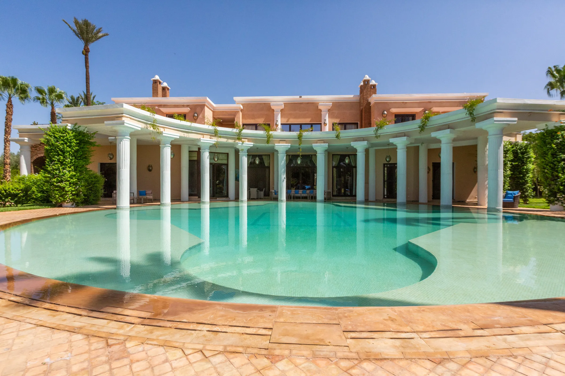 Villa Aegea, private villa rental in the Palmeraie, Marrakech: large pool framed by the villa's colonnade