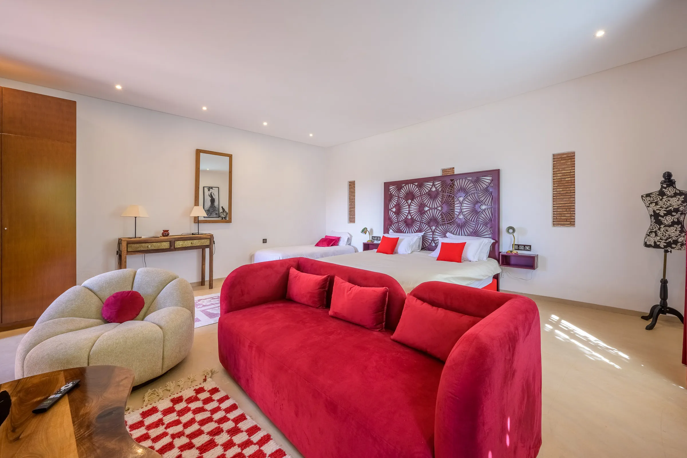 Villa Calypso, private villa rental in the Palmeraie, Marrakech: bedroom with red sofa and sitting area