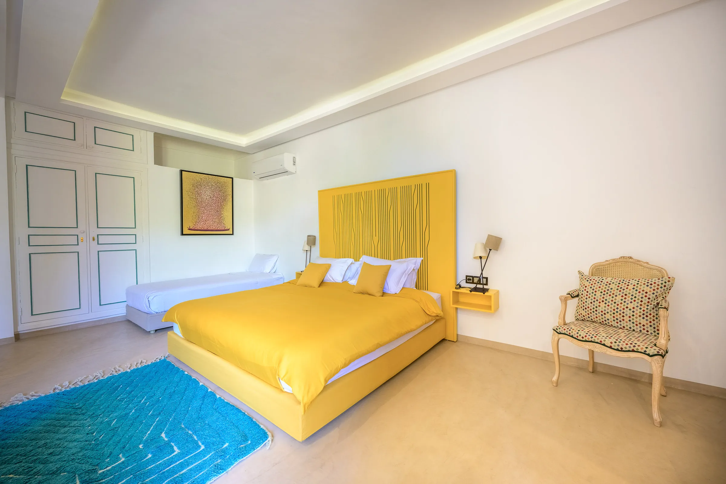 Villa Calypso, private villa rental in the Palmeraie, Marrakech: bedroom with yellow headboard and extra single bed