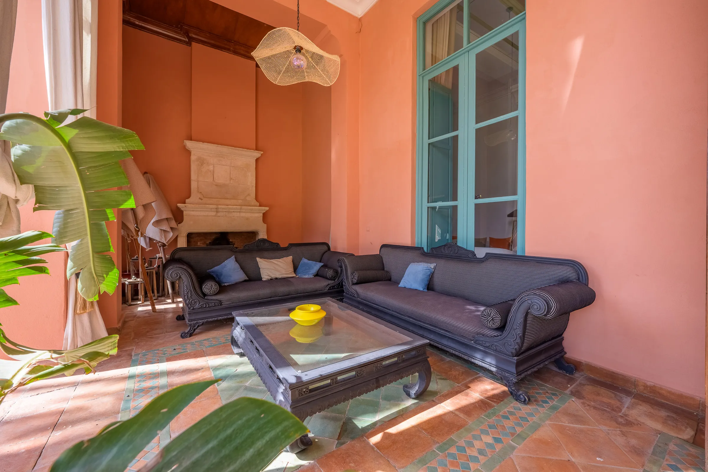 Villa Calypso, private villa rental in the Palmeraie, Marrakech: salmon-pink lounge with sofas and plants