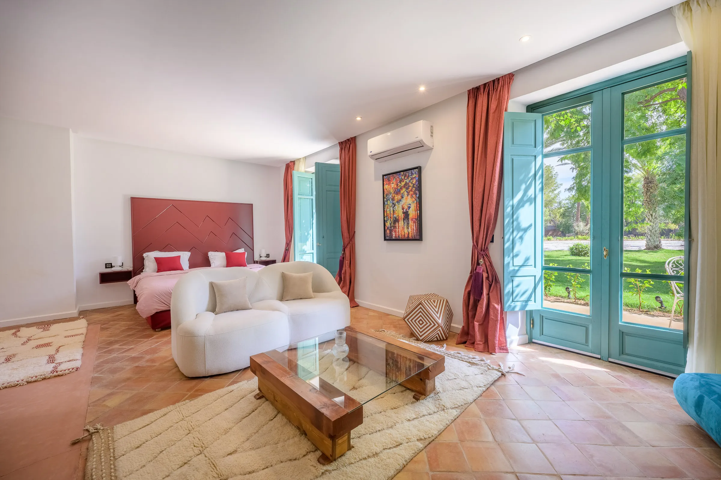 Villa Calypso, private villa rental in the Palmeraie, Marrakech: bedroom with red headboard and lounge area