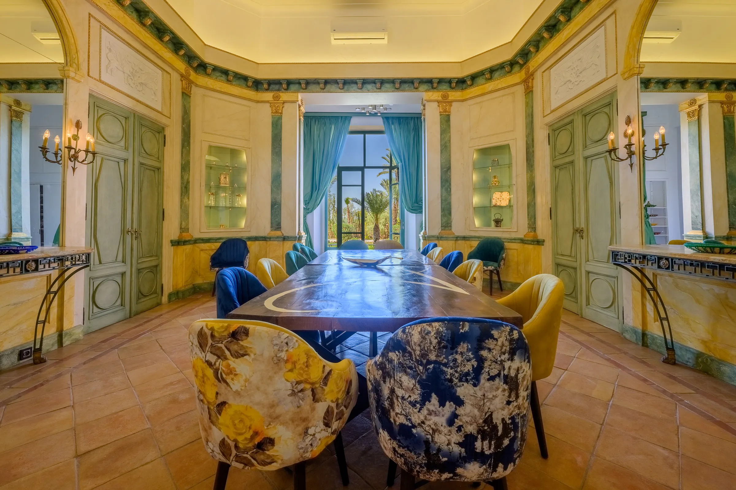 Villa Calypso, private villa rental in the Palmeraie, Marrakech: dining room with long table and velvet chairs