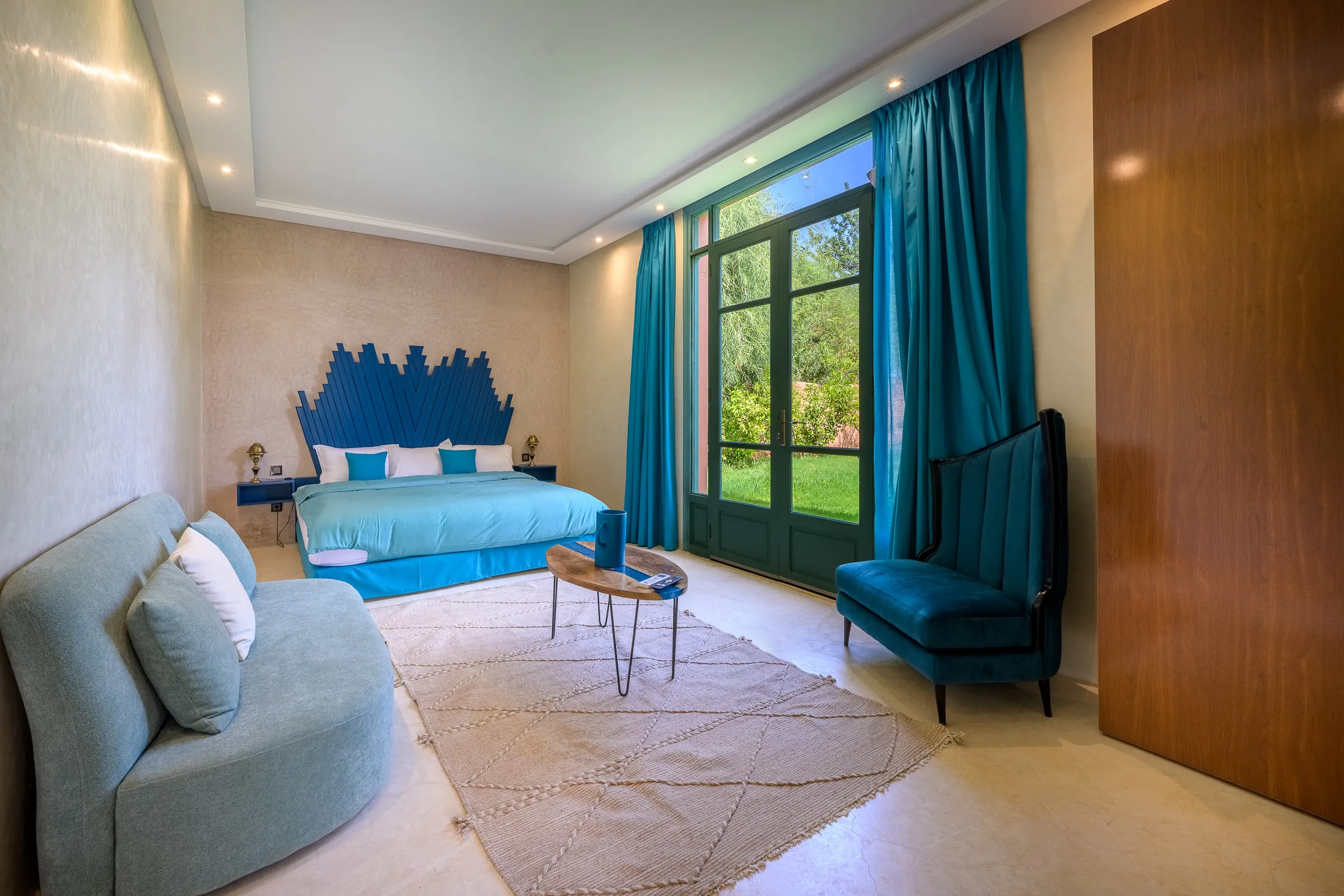 Villa Calypso, private villa rental in the Palmeraie, Marrakech: bedroom with blue headboard and garden doors