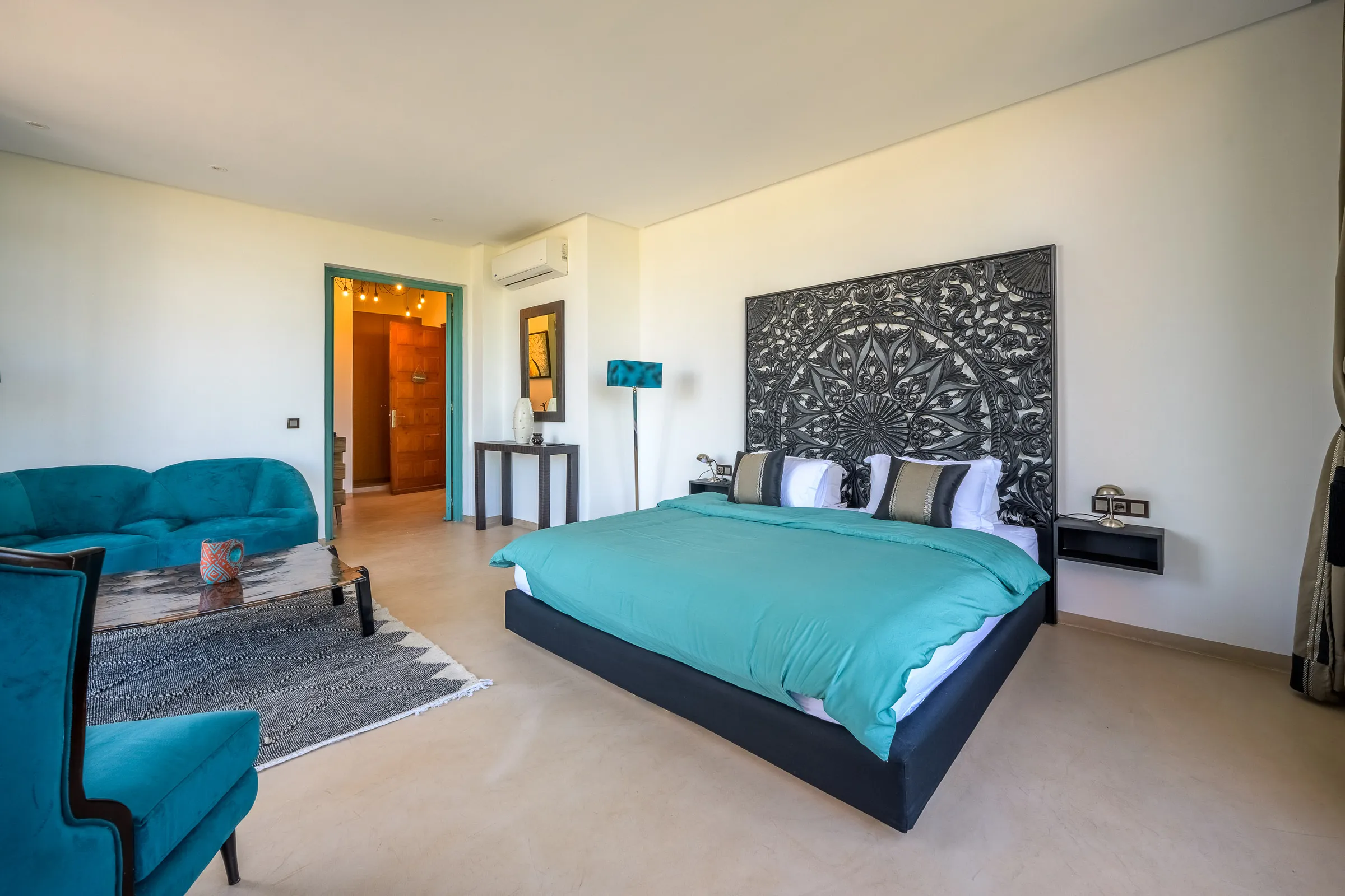 Villa Calypso, private villa rental in the Palmeraie, Marrakech: bedroom with carved headboard and turquoise furnishings