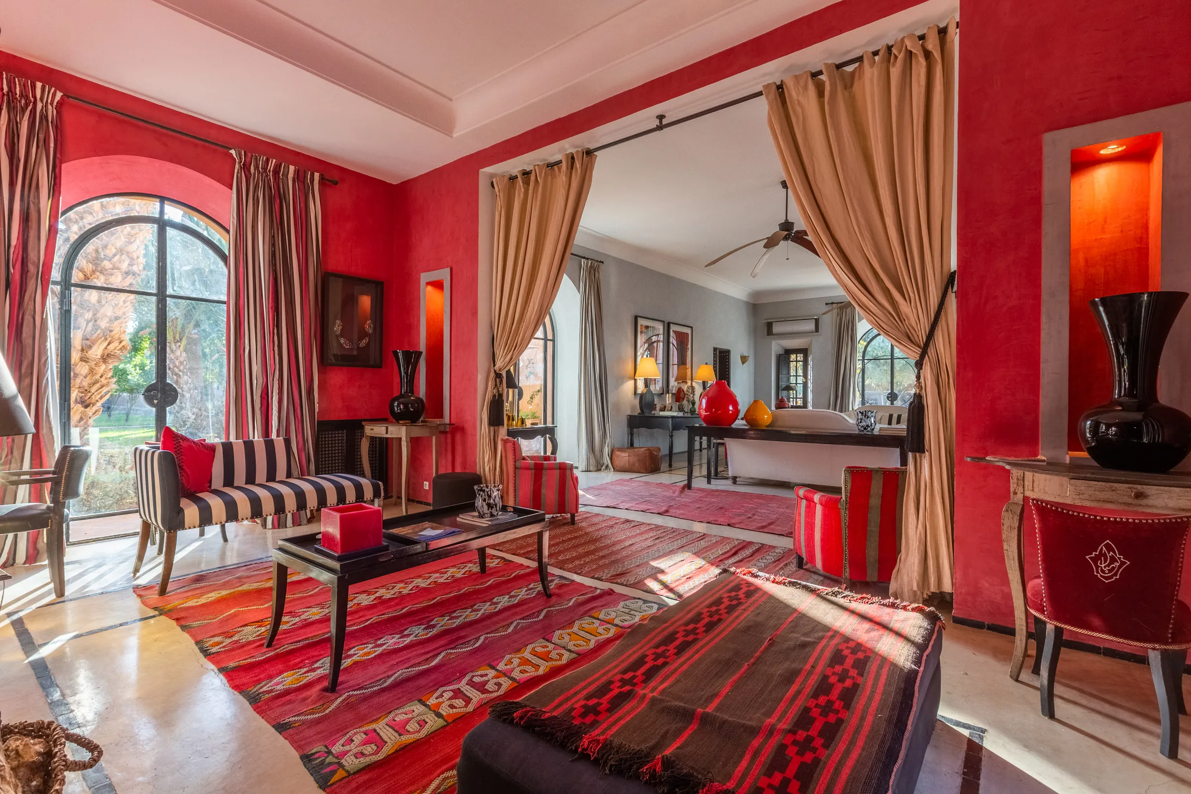 Villa Amalthea, private villa rental in the Palmeraie, Marrakech: red salon with Moroccan rugs