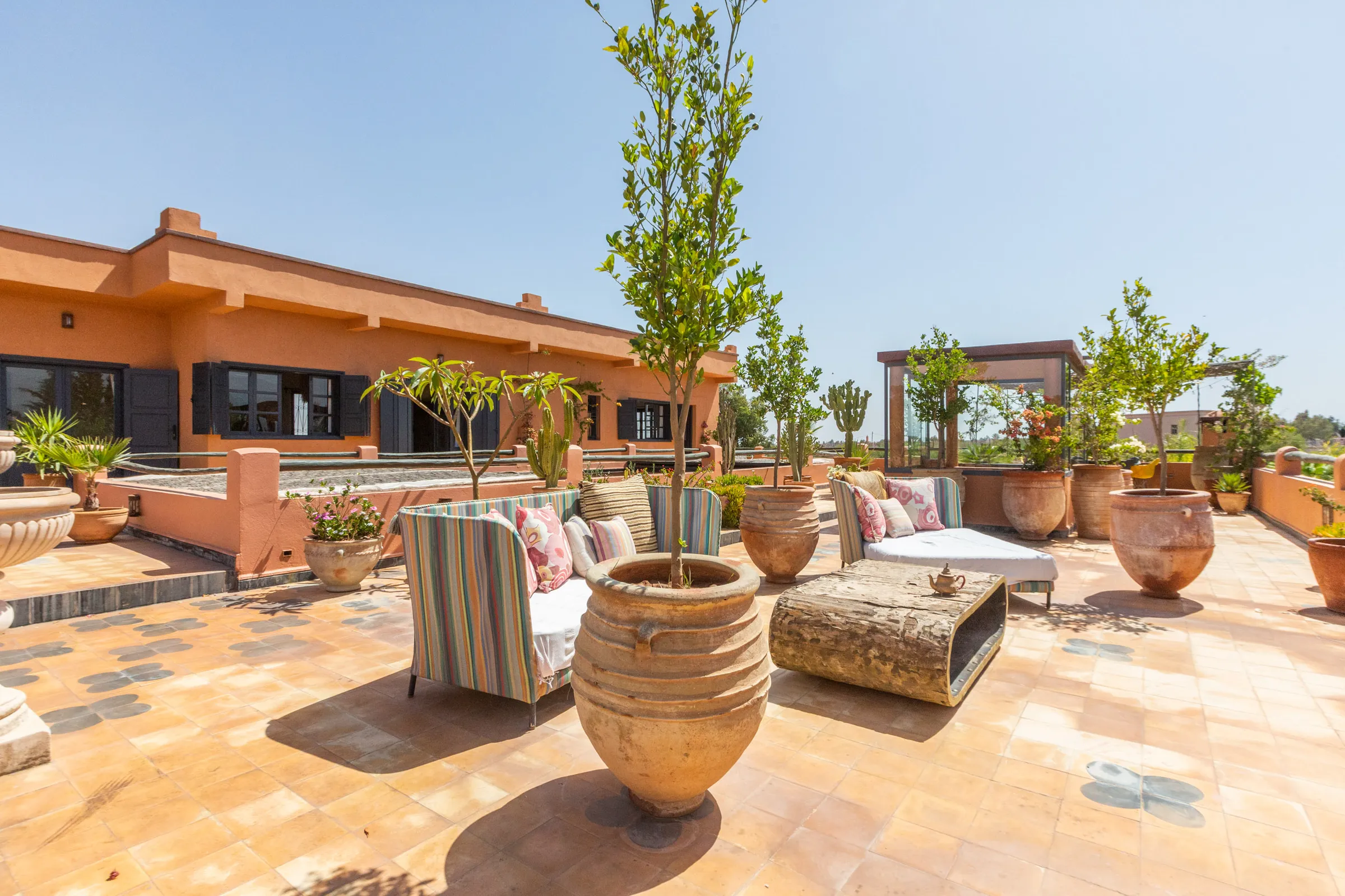 Villa Cassia, private villa rental on the Route de Tahanaout, Marrakech: upper terrace with lounge seating and potted trees
