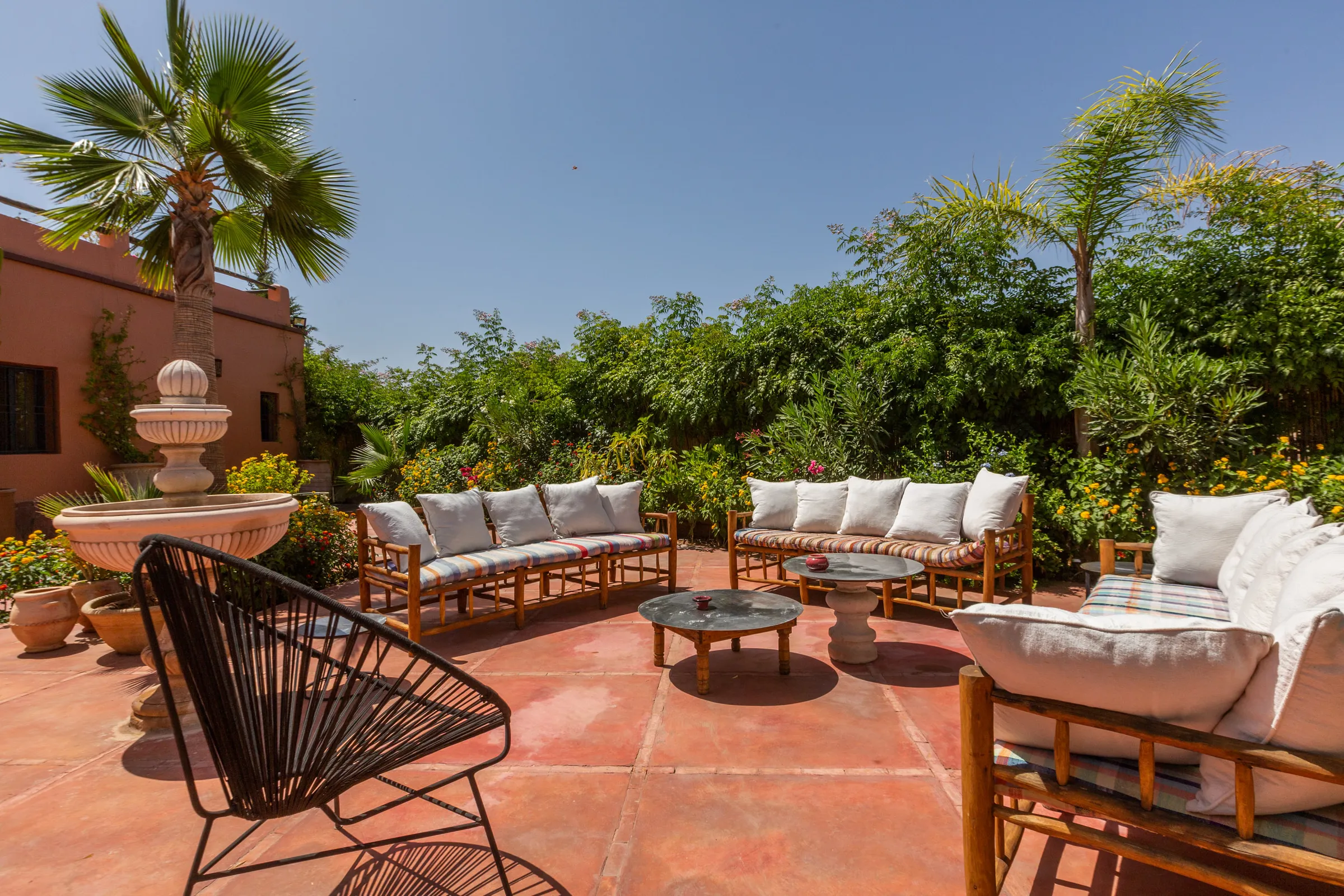 Villa Cassia, private villa rental on the Route de Tahanaout, Marrakech: terrace lounge with fountain and palm trees