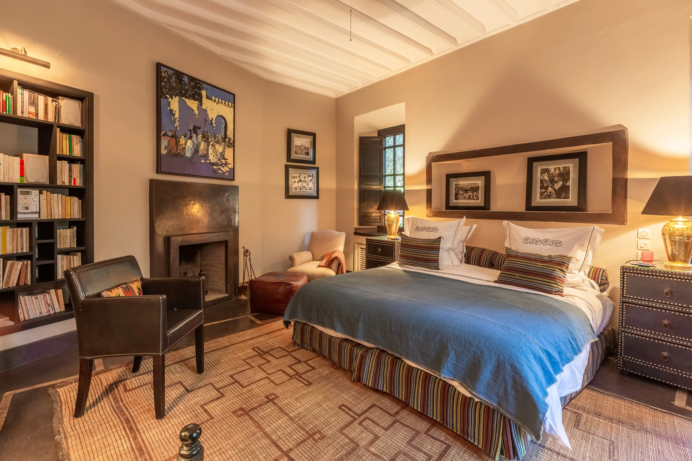 Villa Amalthea, private villa rental in the Palmeraie, Marrakech: bedroom with fireplace and bookshelves