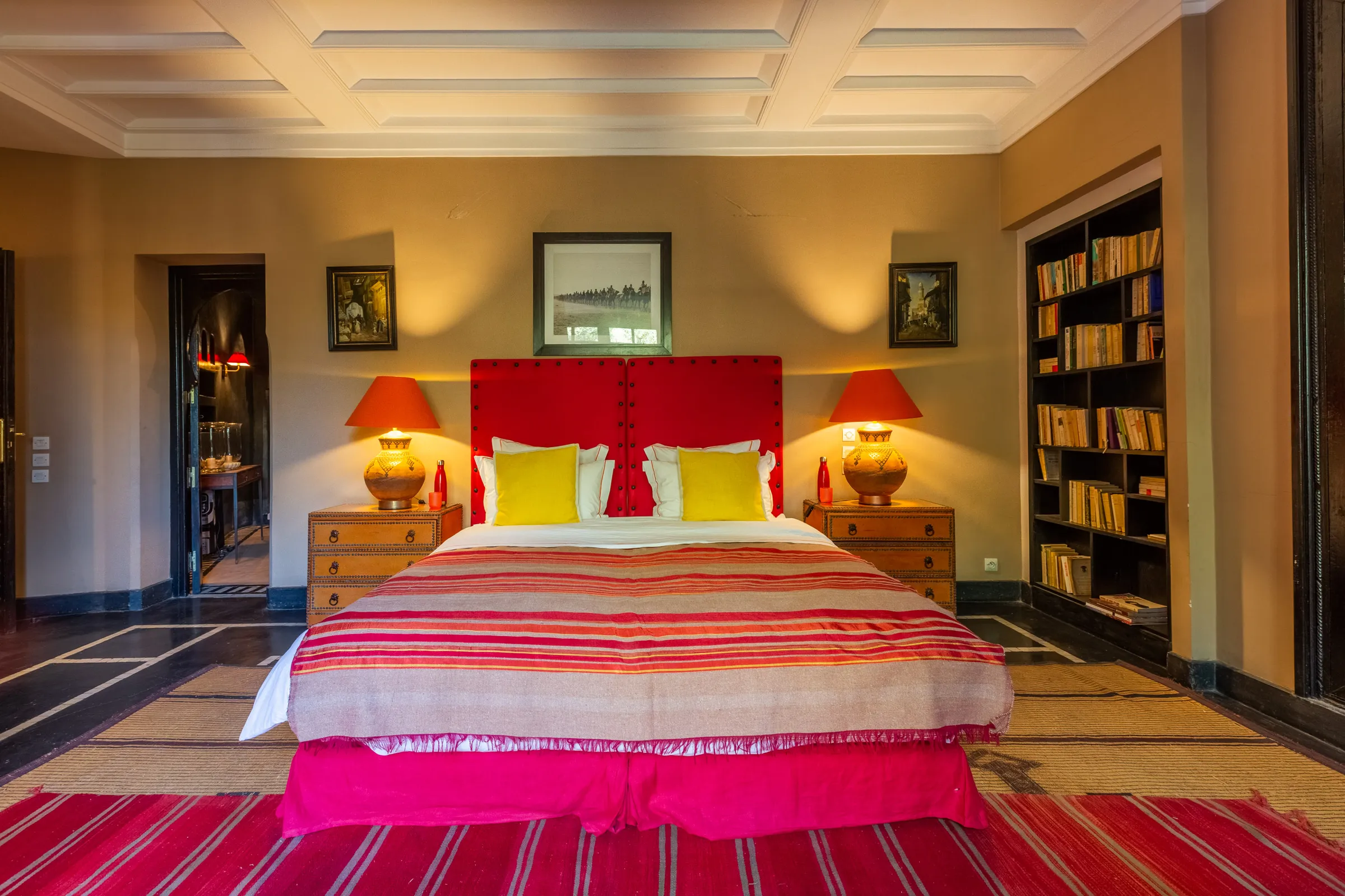 Villa Amalthea, private villa rental in the Palmeraie, Marrakech: bedroom with red headboard and striped bedspread