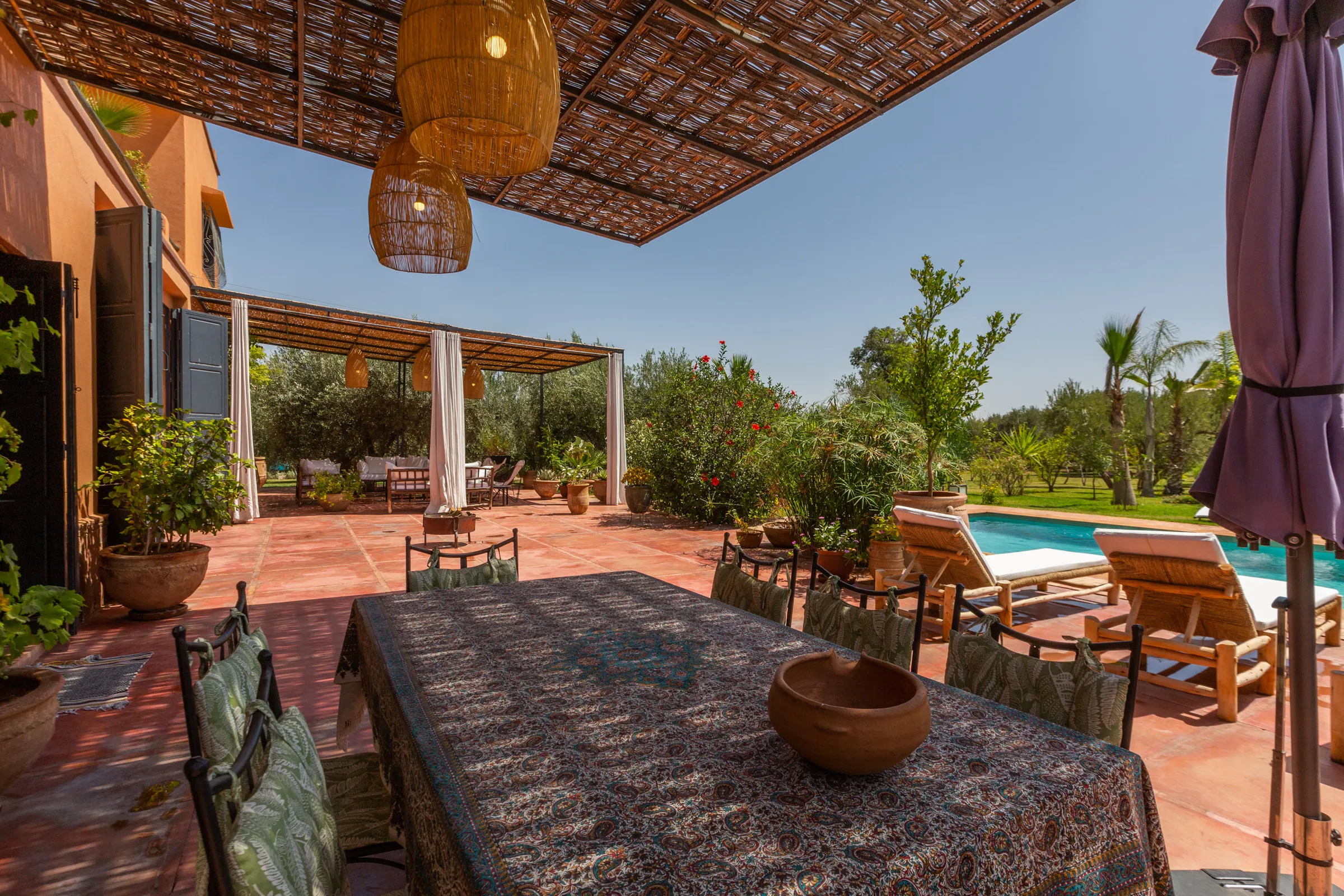 Villa Cassia, private villa rental on the Route de Tahanaout, Marrakech: outdoor dining table under the pergola near the pool
