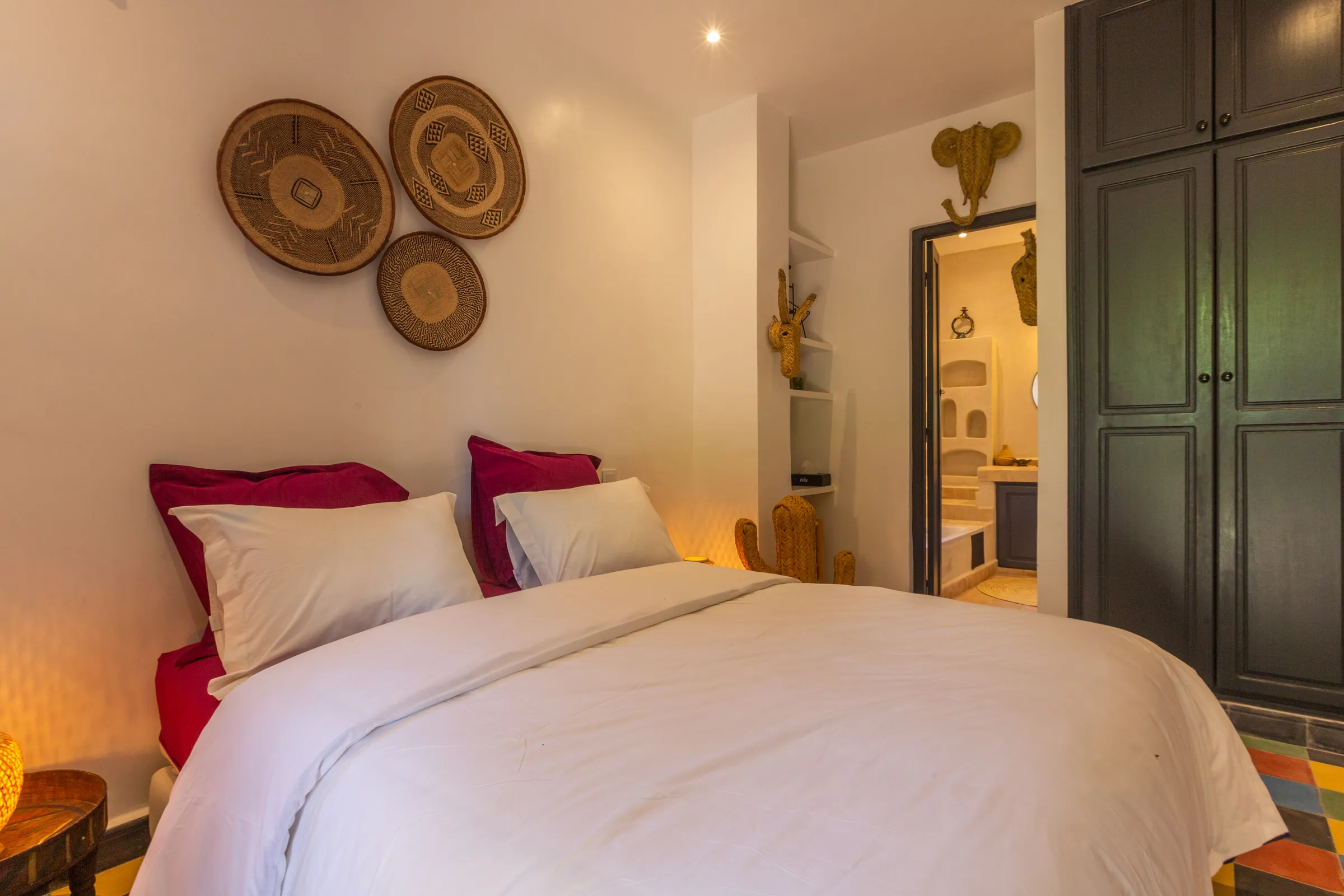 Villa Cassia, private villa rental on the Route de Tahanaout, Marrakech: bedroom decorated with woven wall baskets