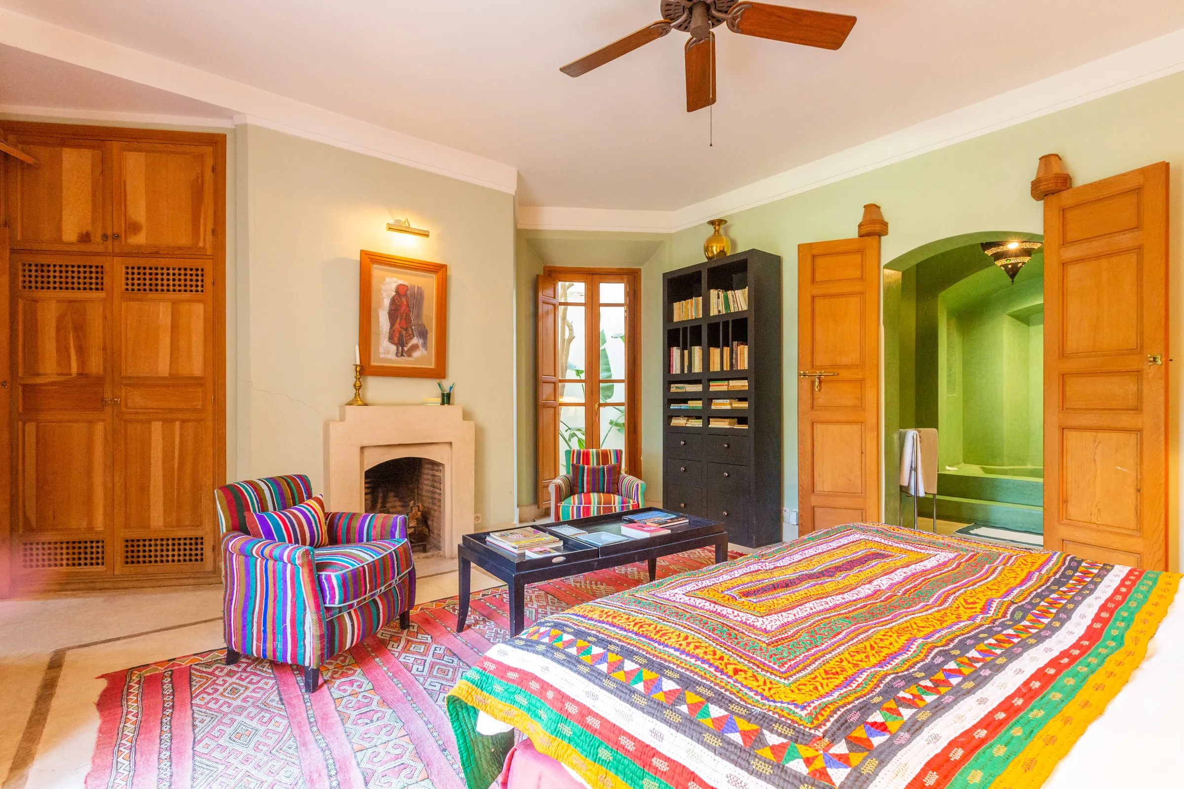 Villa Amalthea, private villa rental in the Palmeraie, Marrakech: bedroom with colourful bedspread and fireplace
