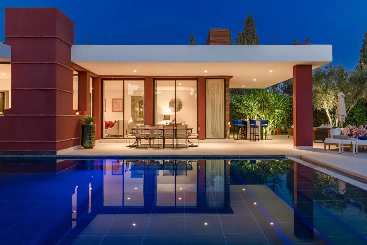 Villa Ersi, private villa rental on the Route de l'Ourika, Marrakech: pool and glass facade at dusk