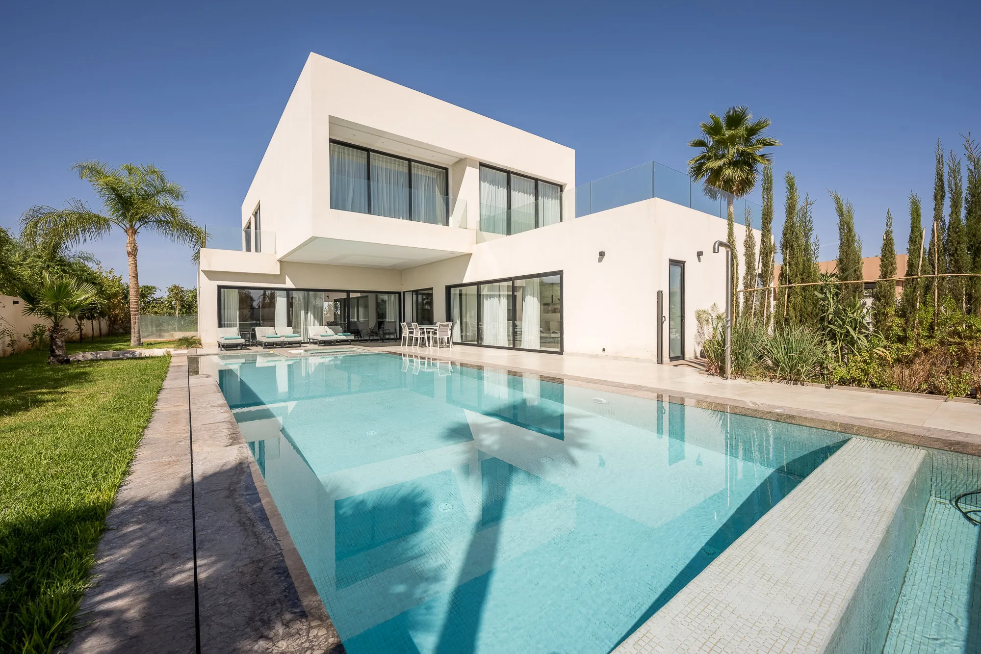 Villa Daphne, private villa rental at Amelkis Golf, Marrakech: contemporary white villa with its long private pool and lawn
