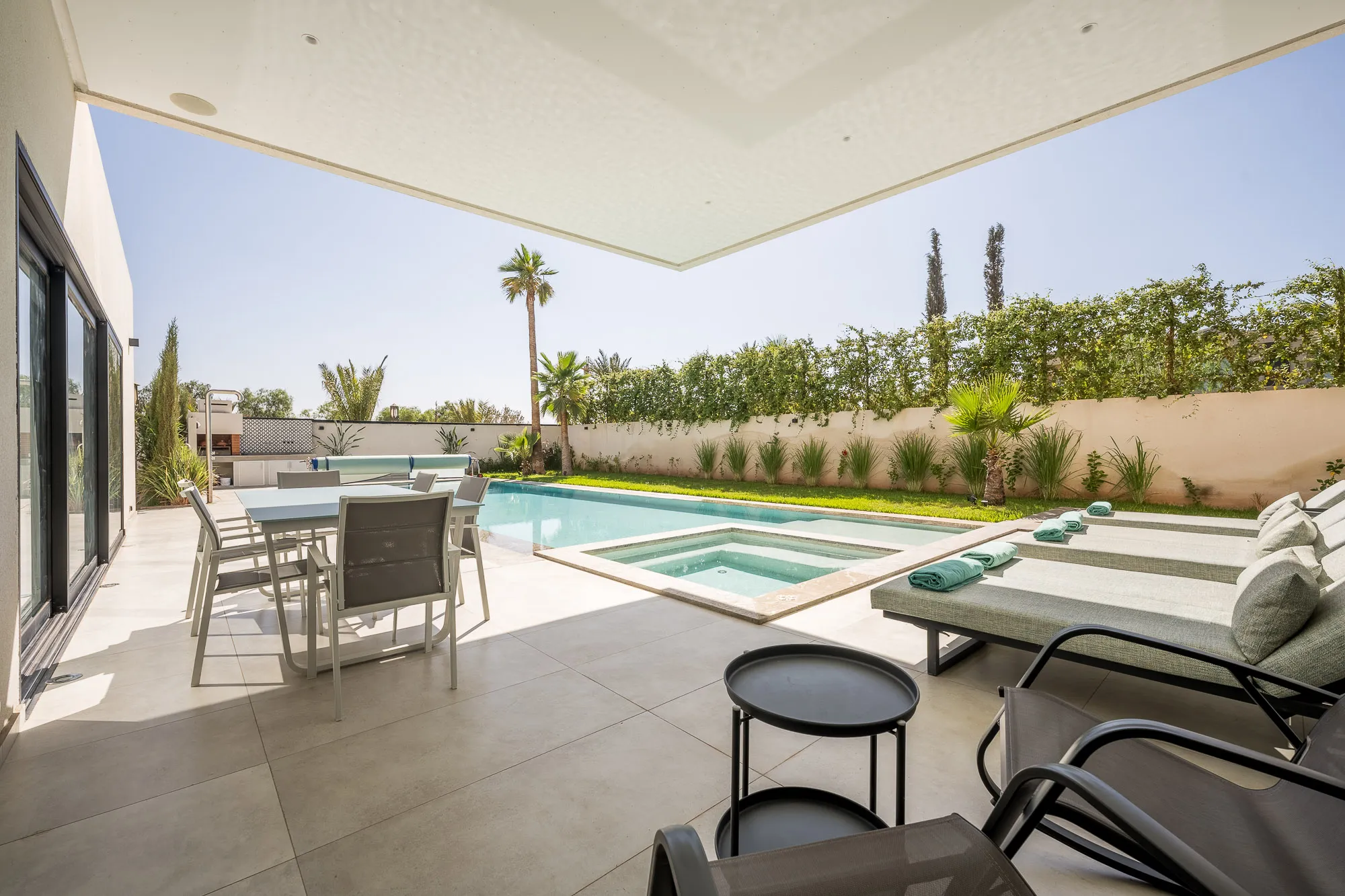 Villa Daphne, private villa rental at Amelkis Golf, Marrakech: covered terrace with outdoor dining table overlooking the pool