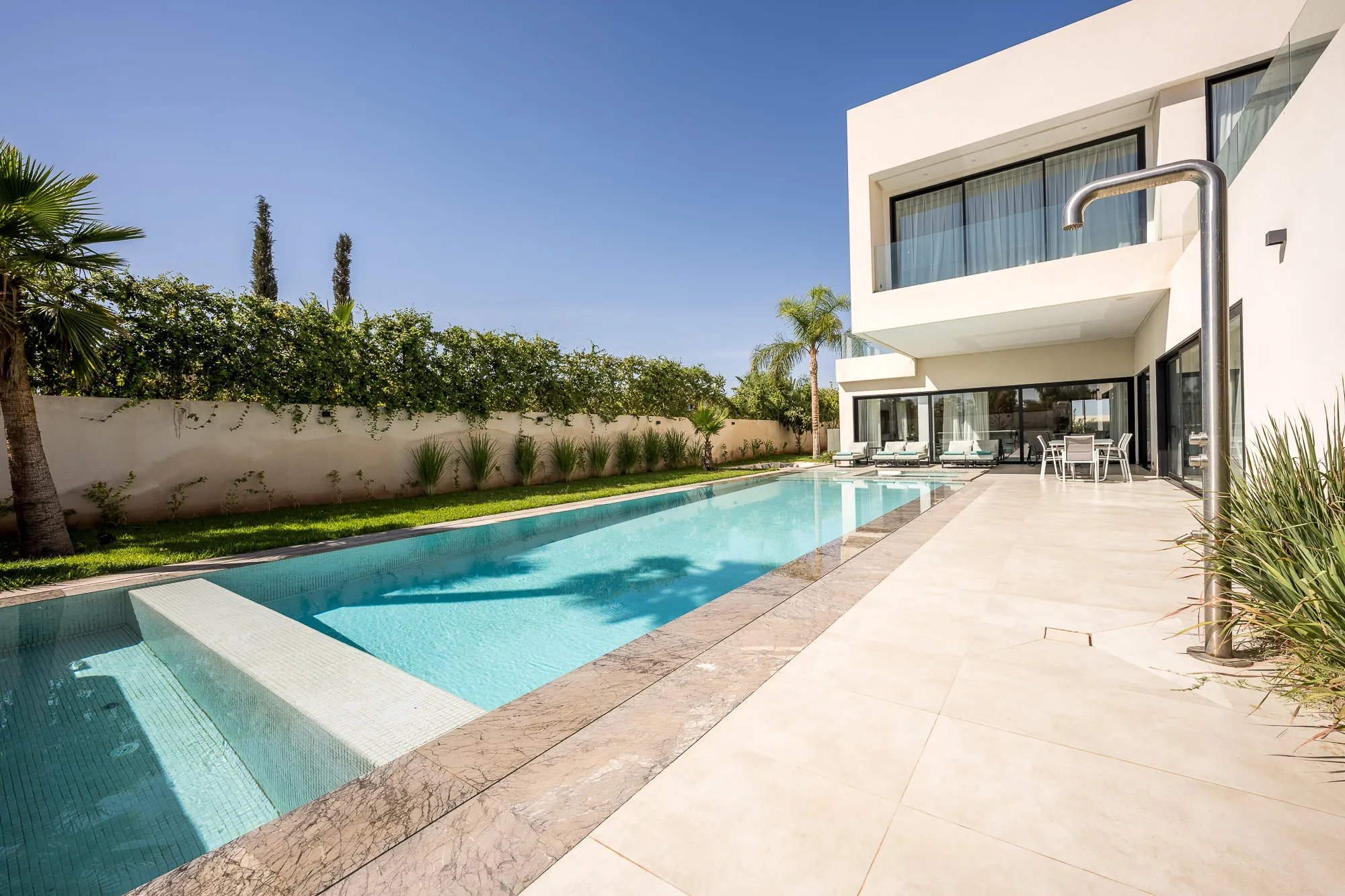 Villa Daphne, private villa rental at Amelkis Golf, Marrakech: long swimming pool bordered by a stone terrace and hedges