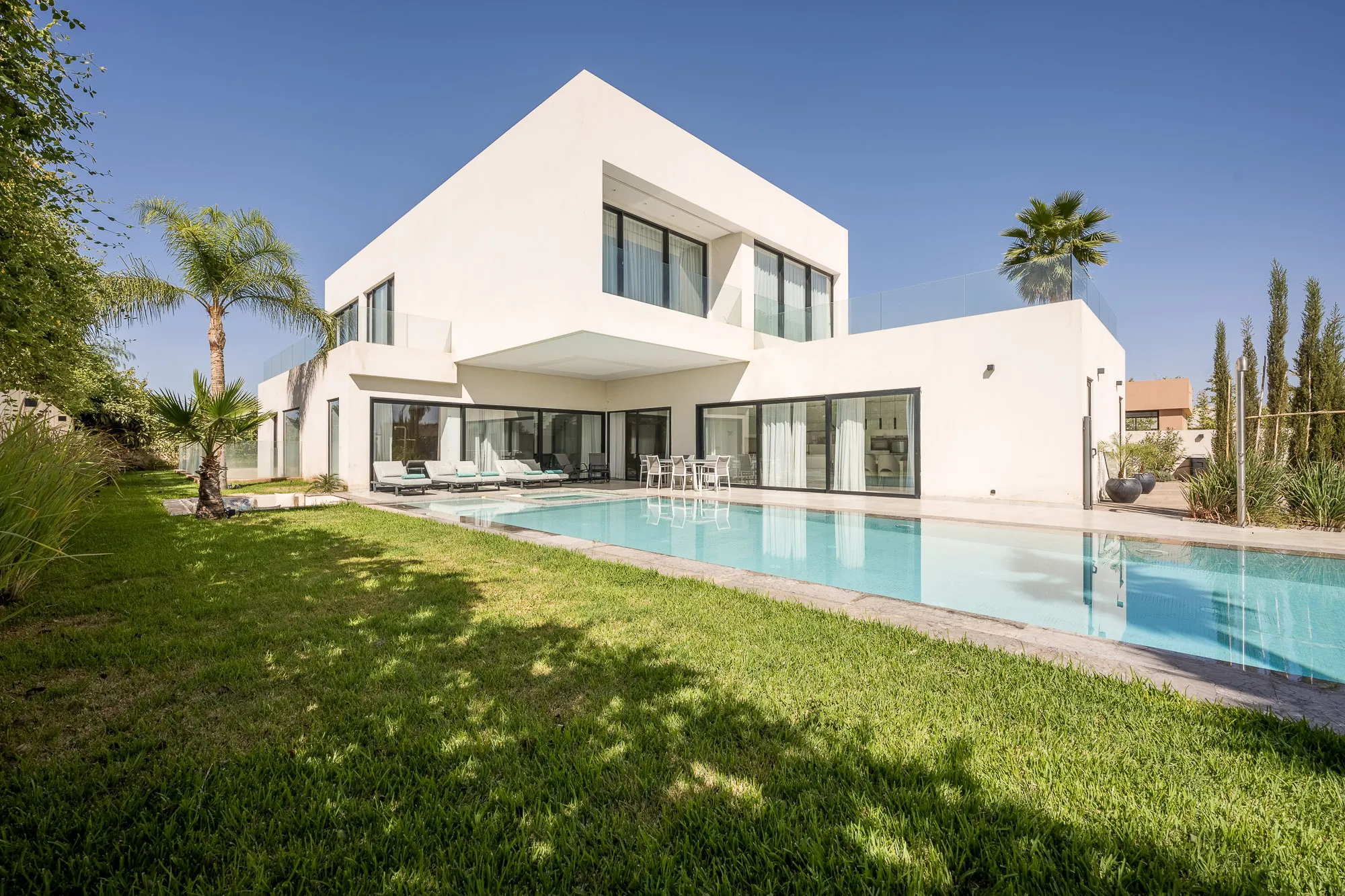 Villa Daphne, private villa rental at Amelkis Golf, Marrakech: lawn and palm trees in front of the villa and pool