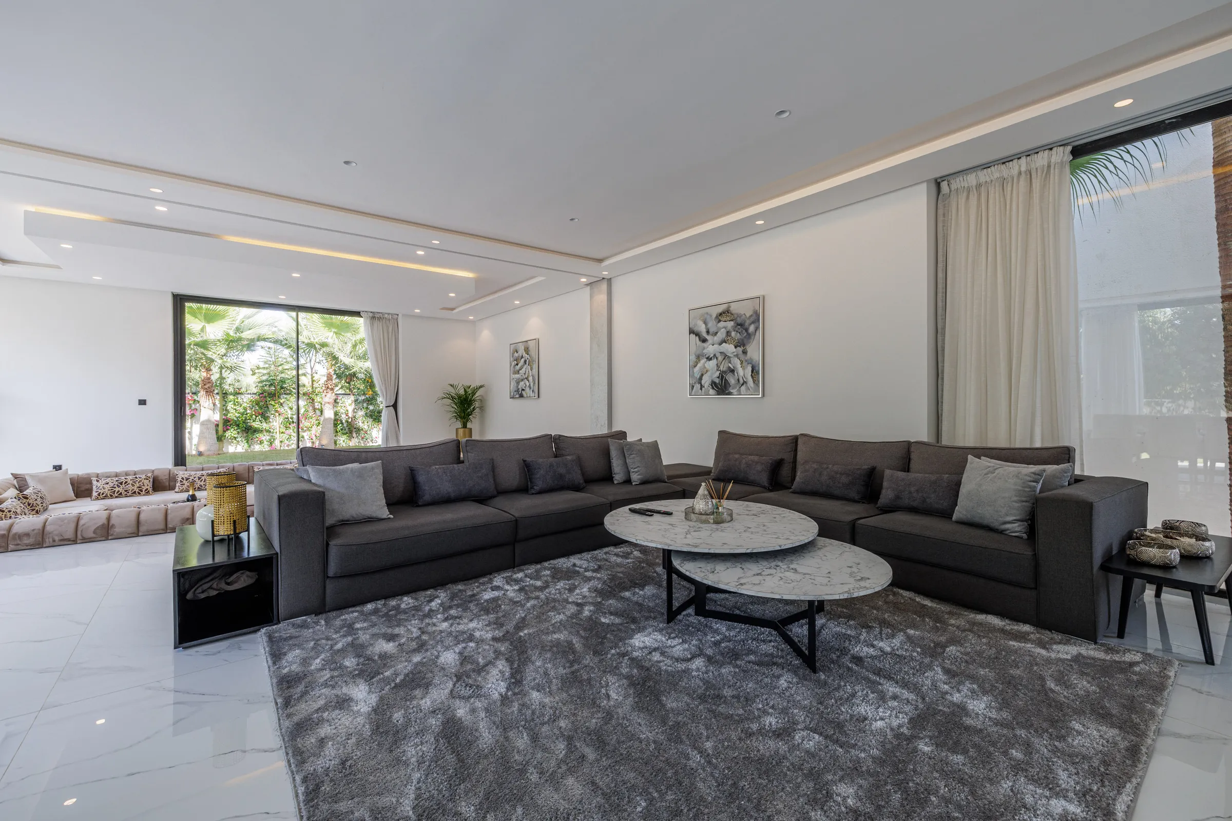 Villa Nefeli, private villa rental at Amelkis Golf, Marrakech: living room with grey sofas and floor-to-ceiling windows