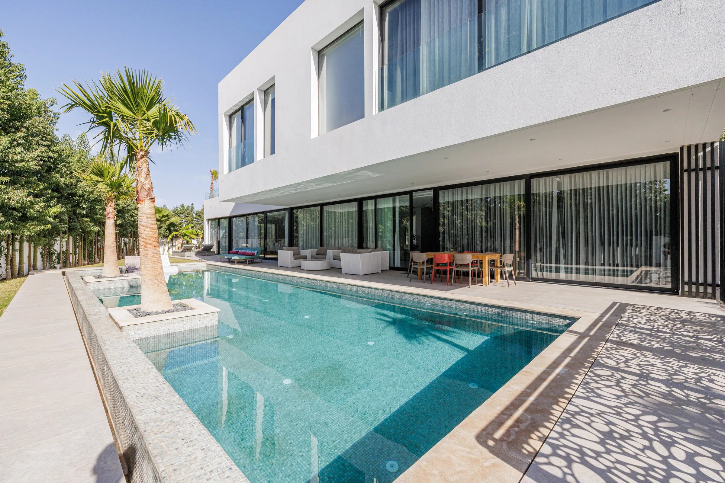 Villa Nefeli, private villa rental at Amelkis Golf, Marrakech: swimming pool running along the villa with palm trees
