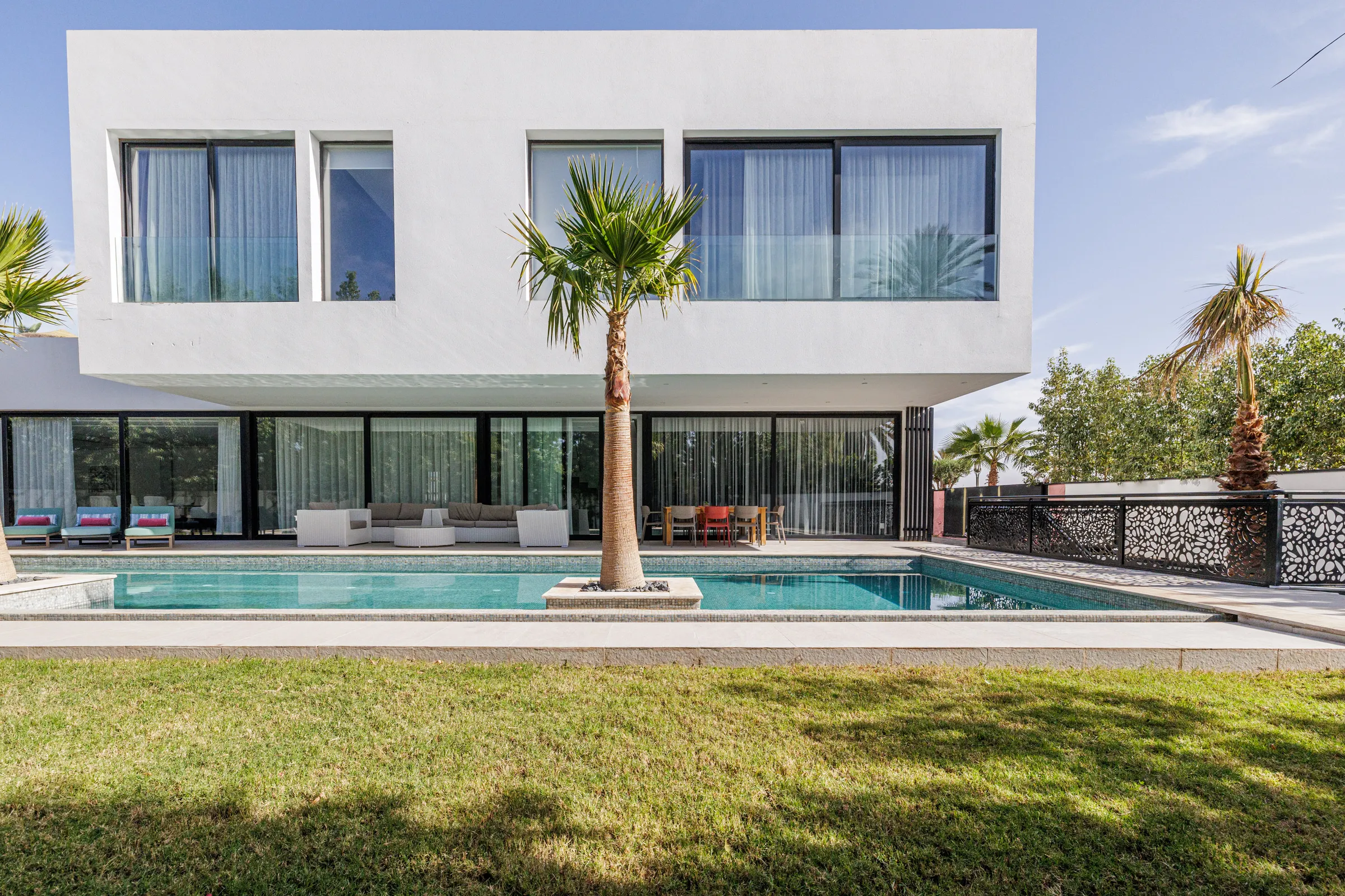Villa Nefeli, private villa rental at Amelkis Golf, Marrakech: contemporary white facade with lawn and swimming pool