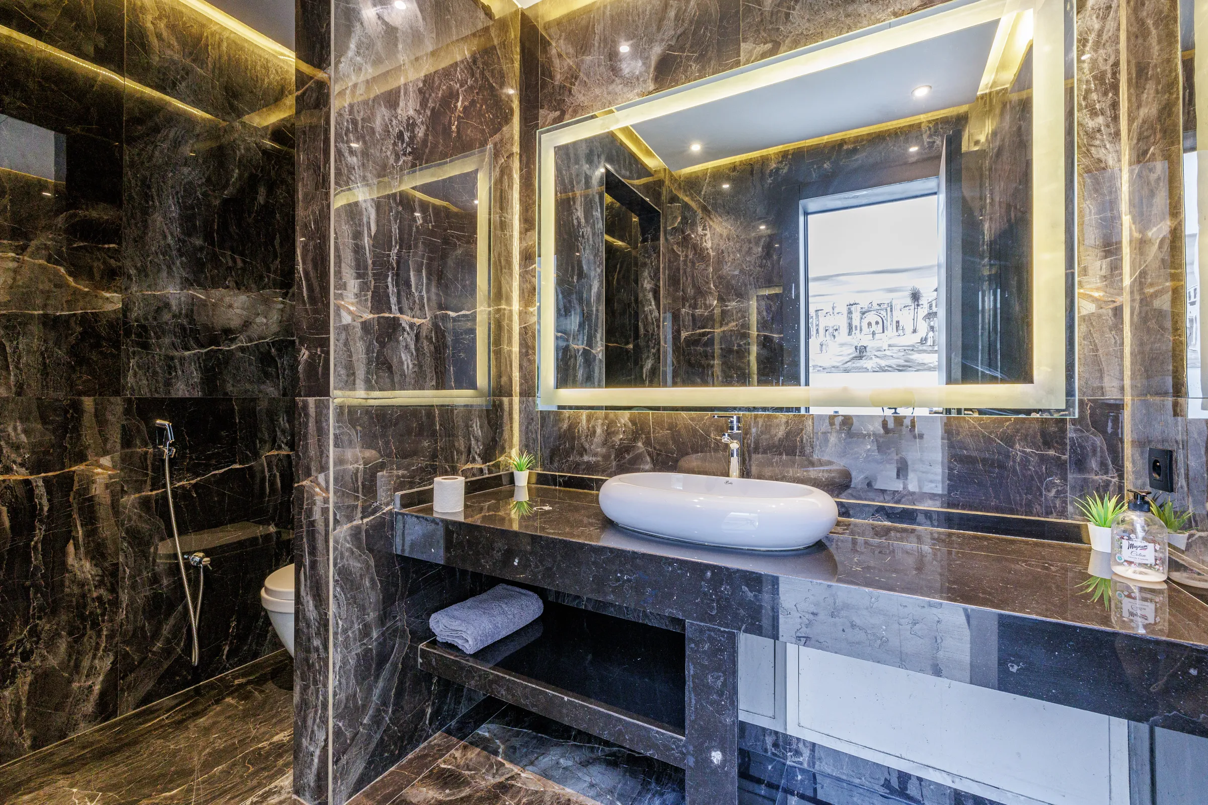 Villa Nefeli, private villa rental at Amelkis Golf, Marrakech: dark marble bathroom with backlit mirror