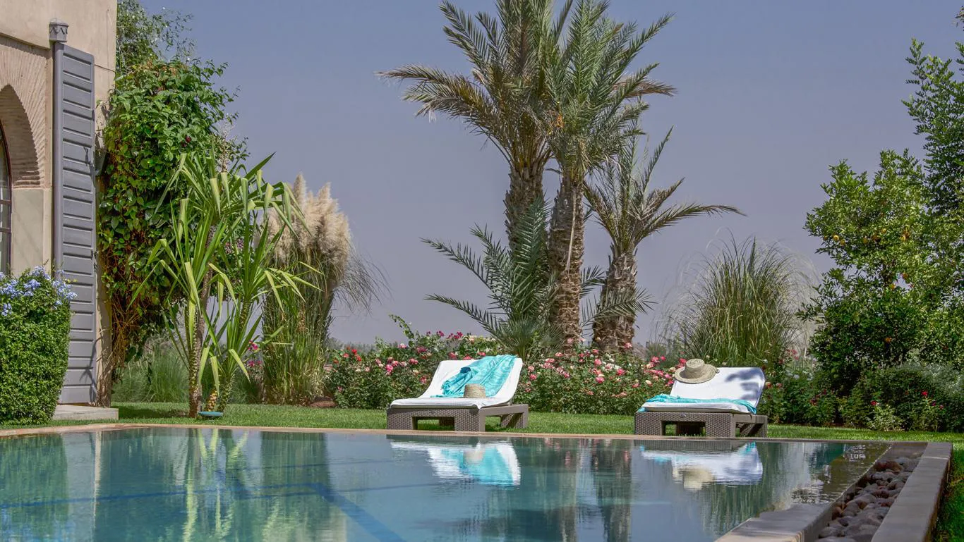 Villa Myrto, private villa rental at Amelkis Golf, Marrakech: poolside loungers with palm trees