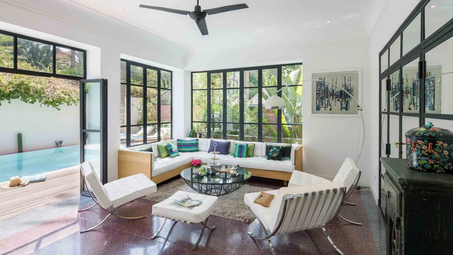 Villa Leda, private villa rental near Majorelle, Marrakech: living room with steel-framed windows opening onto the pool
