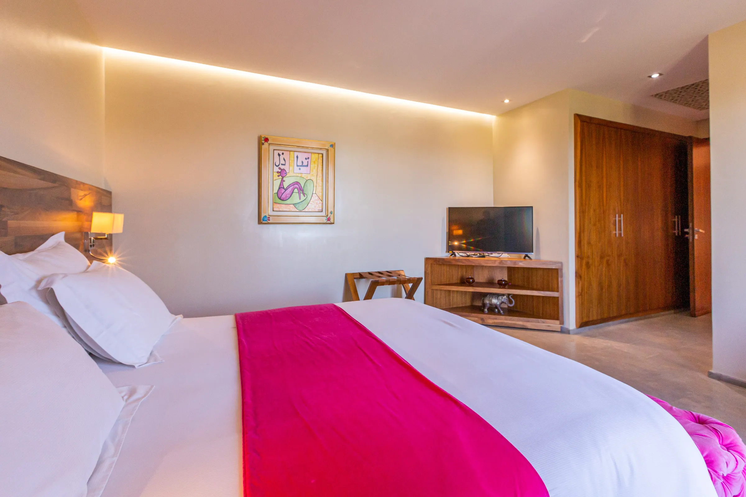 Villa Ismene, private villa rental at Samanah Golf, Marrakech: bedroom with pink throw and television