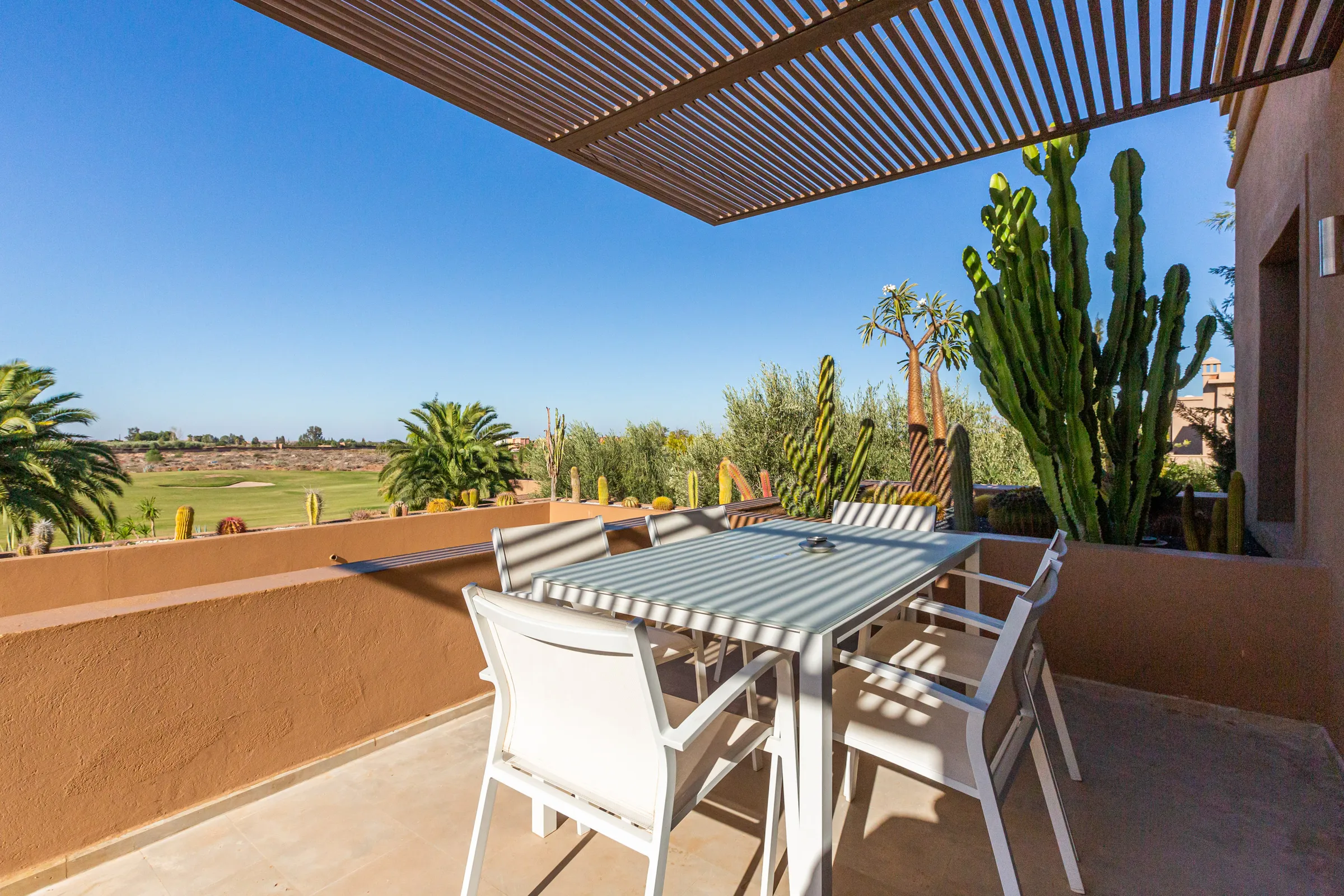 Villa Ismene, private villa rental at Samanah Golf, Marrakech: terrace dining table with views over the golf course