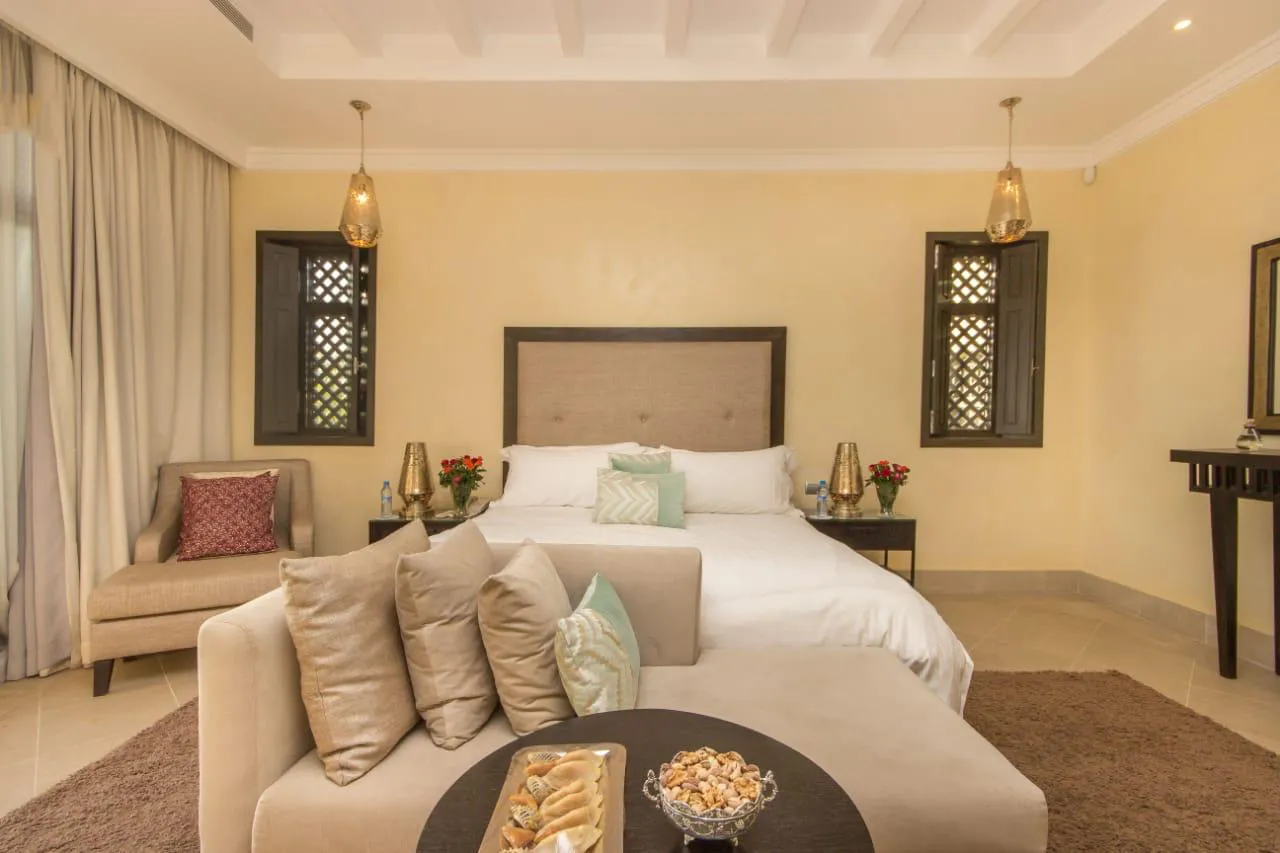 Villa Kyma, private villa rental at the Four Seasons Resort, Marrakech: bedroom with sofa and lattice shutters