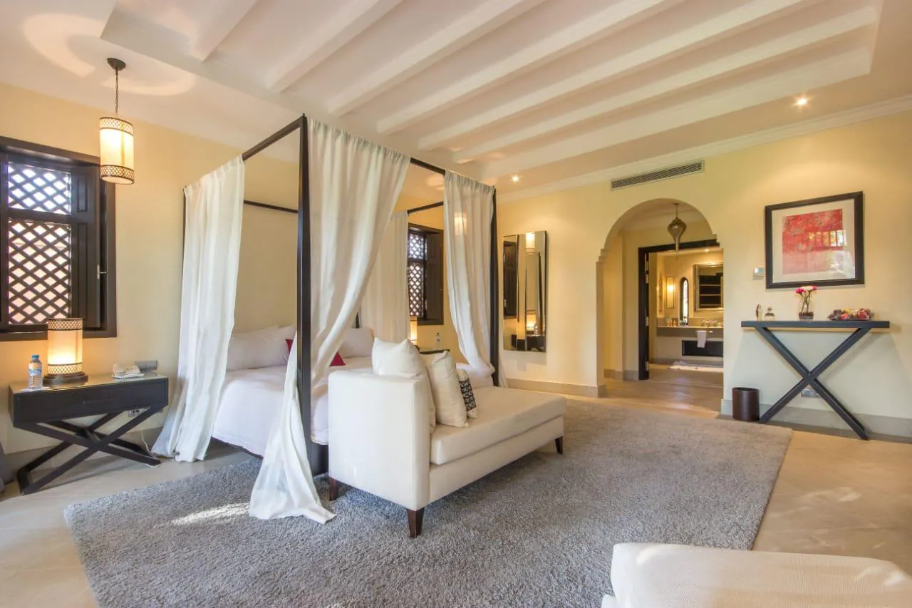 Villa Kyma, private villa rental at the Four Seasons Resort, Marrakech: bedroom with canopy bed and sofa